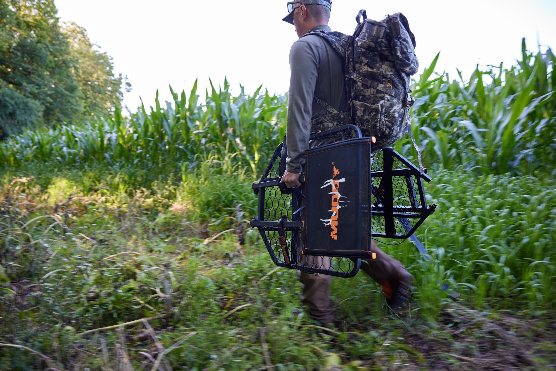 A hunter carrying gear in a field, deer season Georgia 2024 concept. 