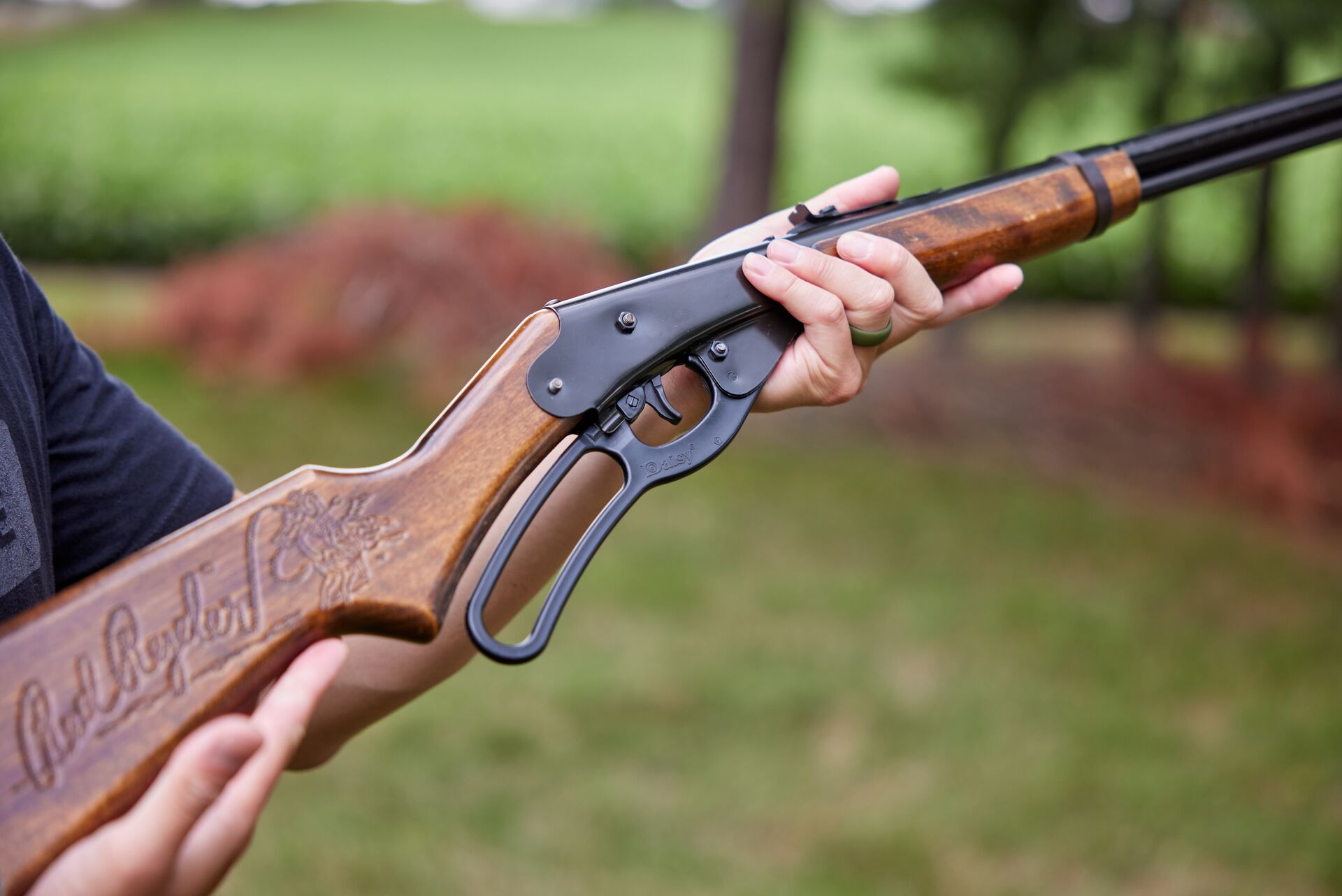 Close-up of hands holding a rilfe, choosing the right firearm for a hunt concept. 