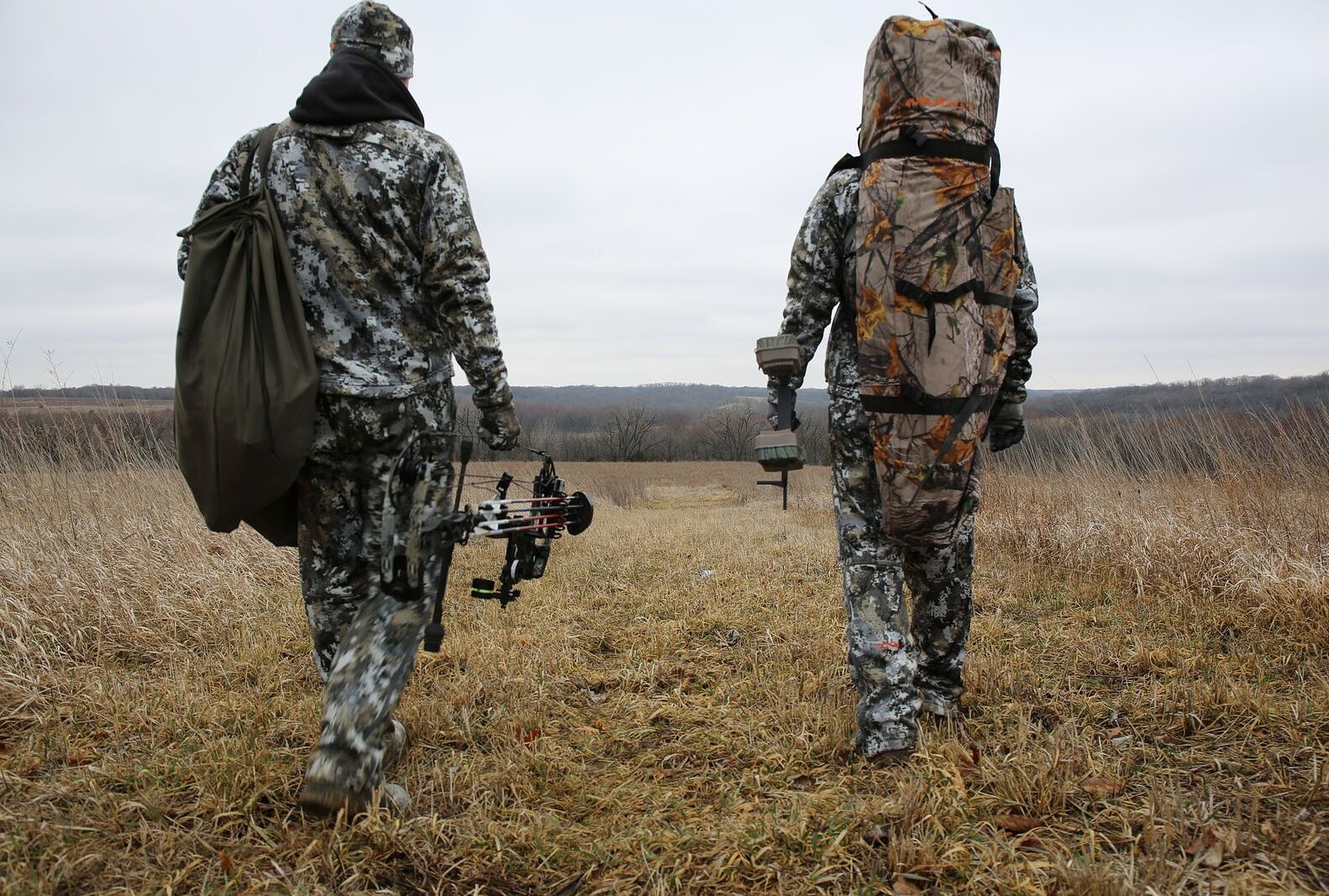 Two hunters with gear heading out into the field, hunting blacktail deer concept. 