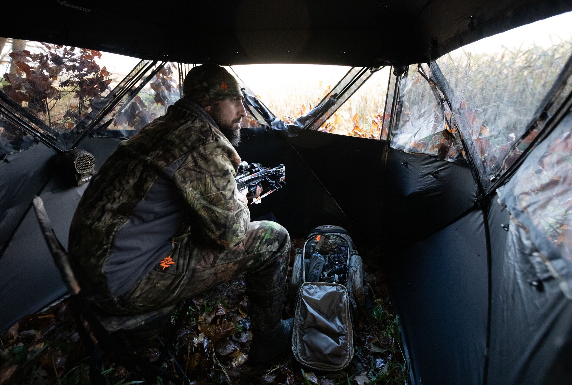 A hunter in camo in a hunting blind, using scent blockers concept. 