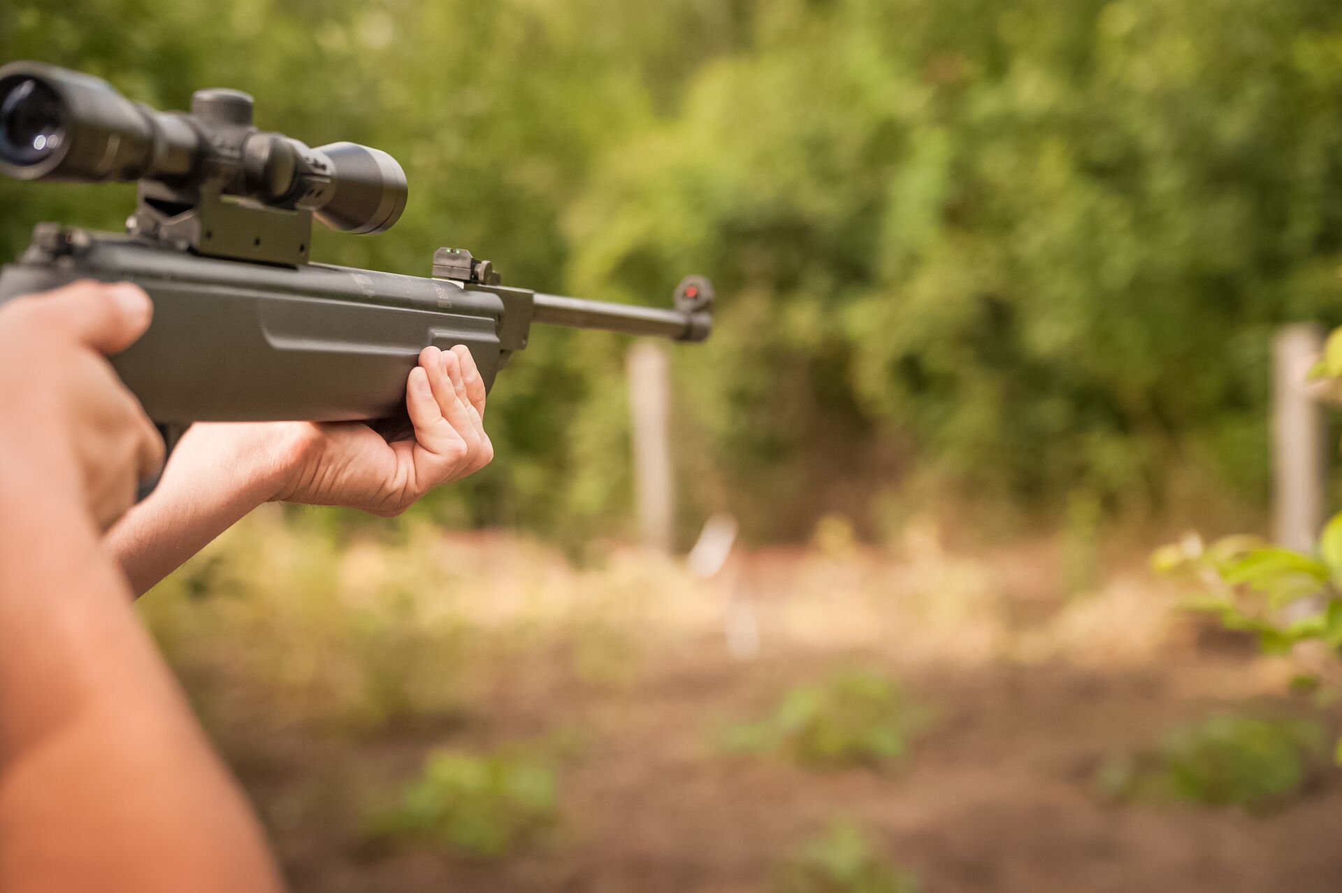 Close-up of hands aiming an air rifle. 