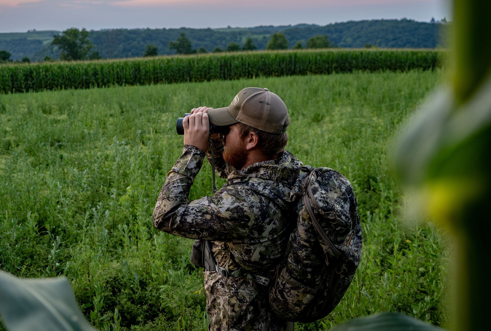 A hunter using binoculars, finding the best locations to hunt during AL deer season concept. .