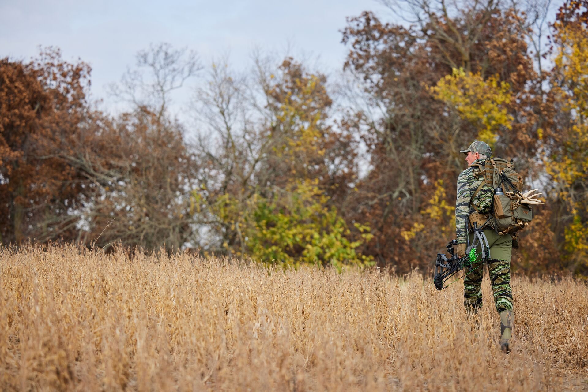 Hunter John Dudley walks a field with hunting gear, how to get permission to hunt private land concept.