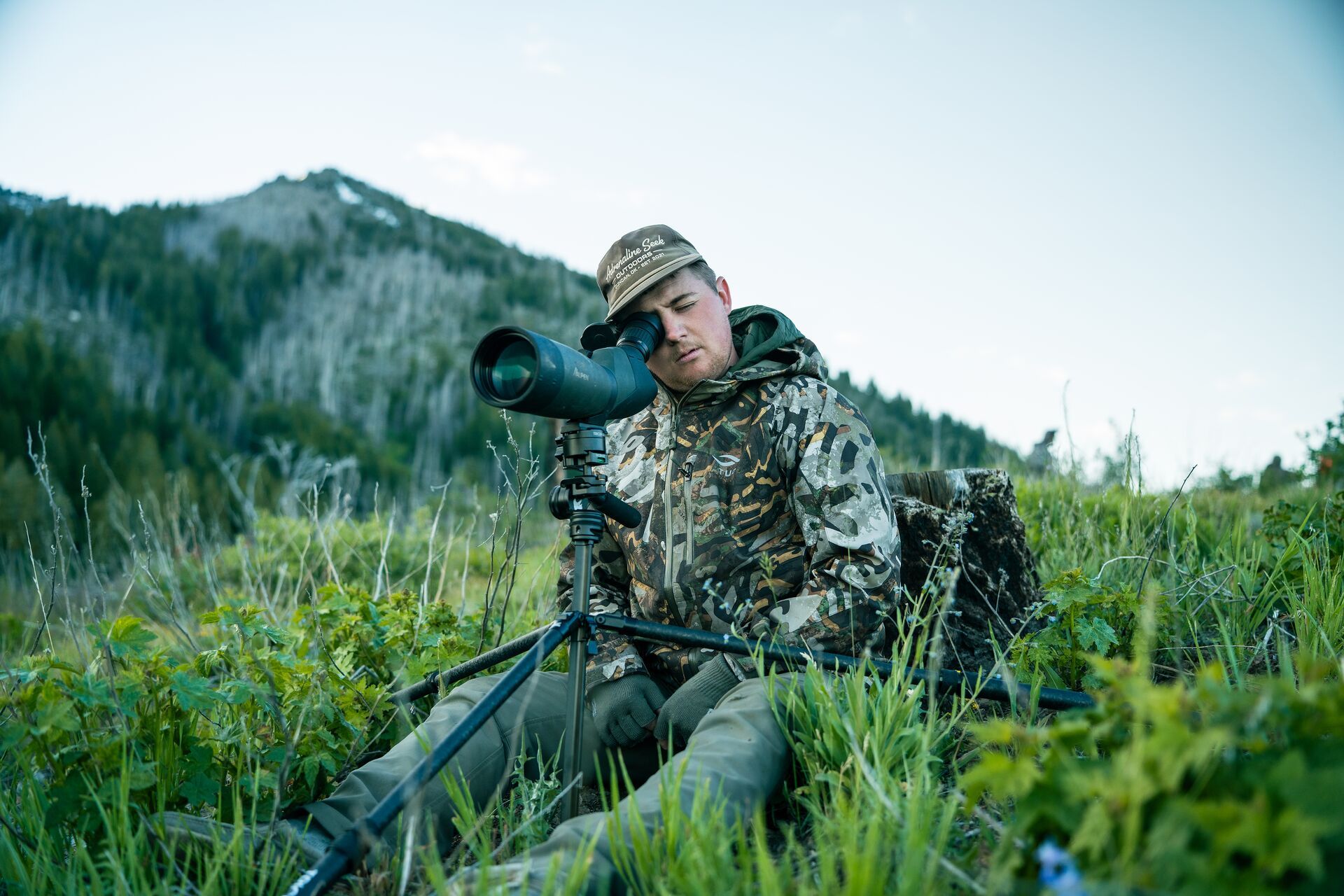 Hunter on hill using scope, how to find mule deer concept. 