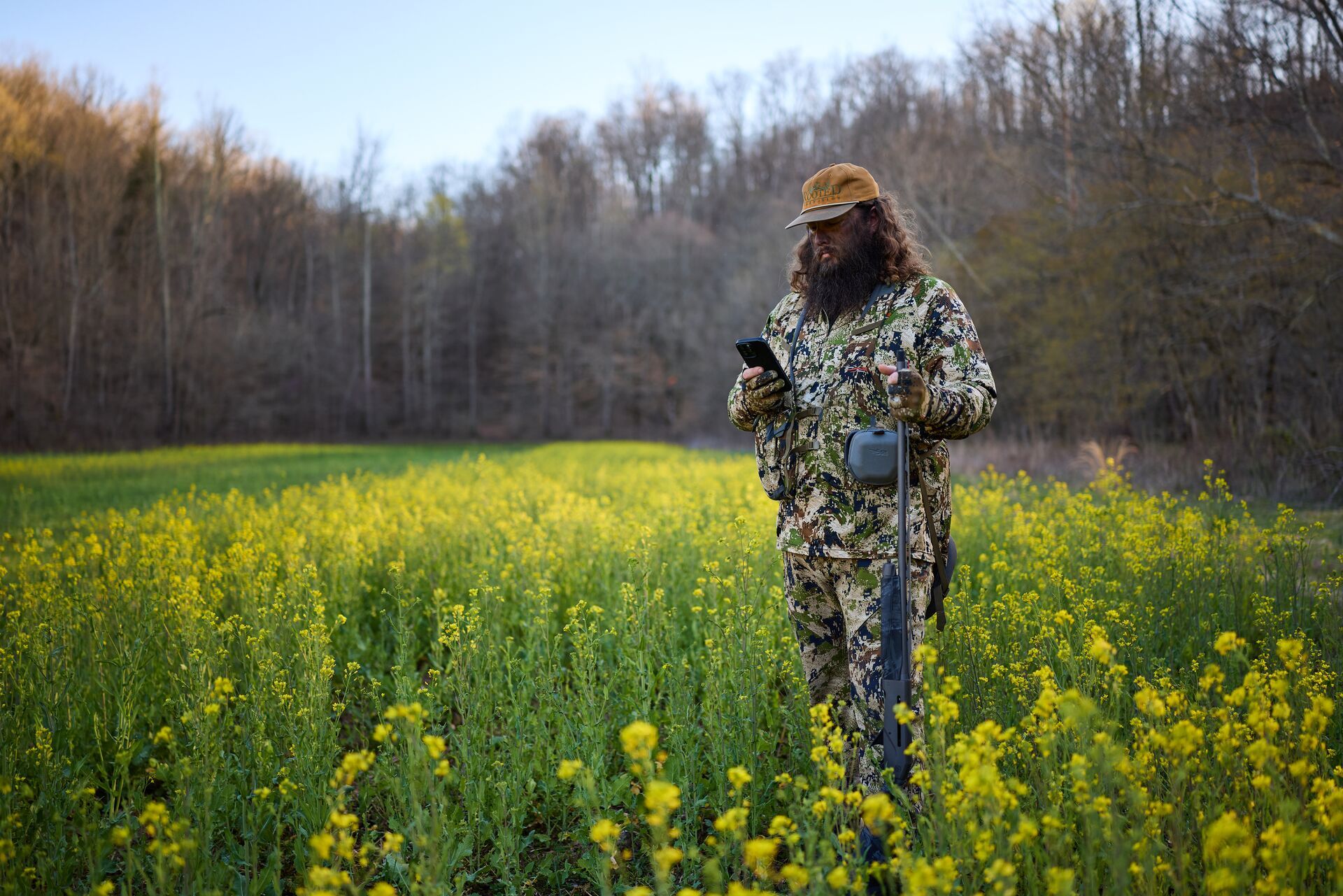 Hunter uses HuntWise on phone in a field, Colorado spring turkey season concept. 
