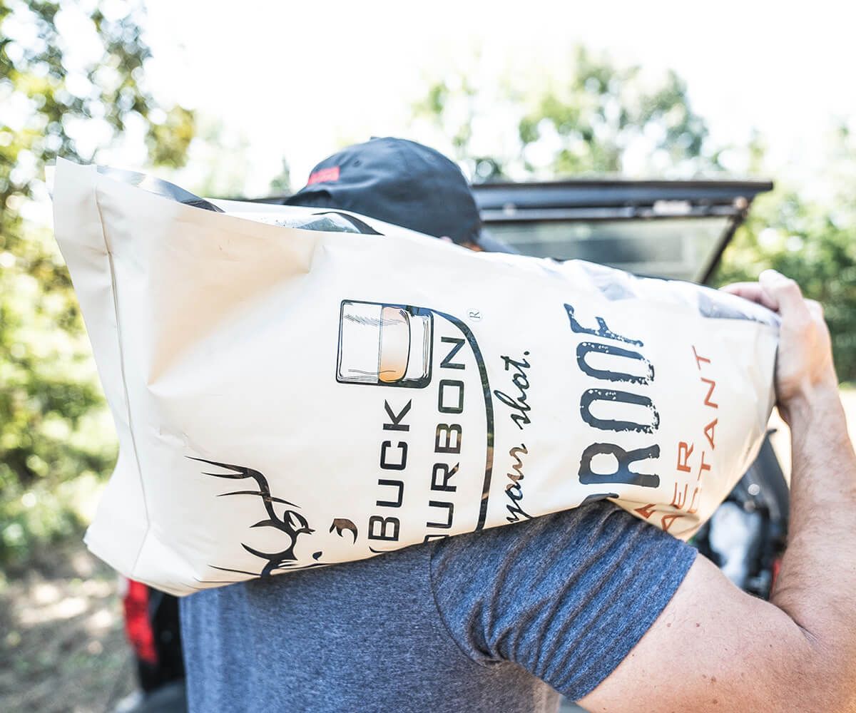 Hunter with bag of deer feed over shoulder. 