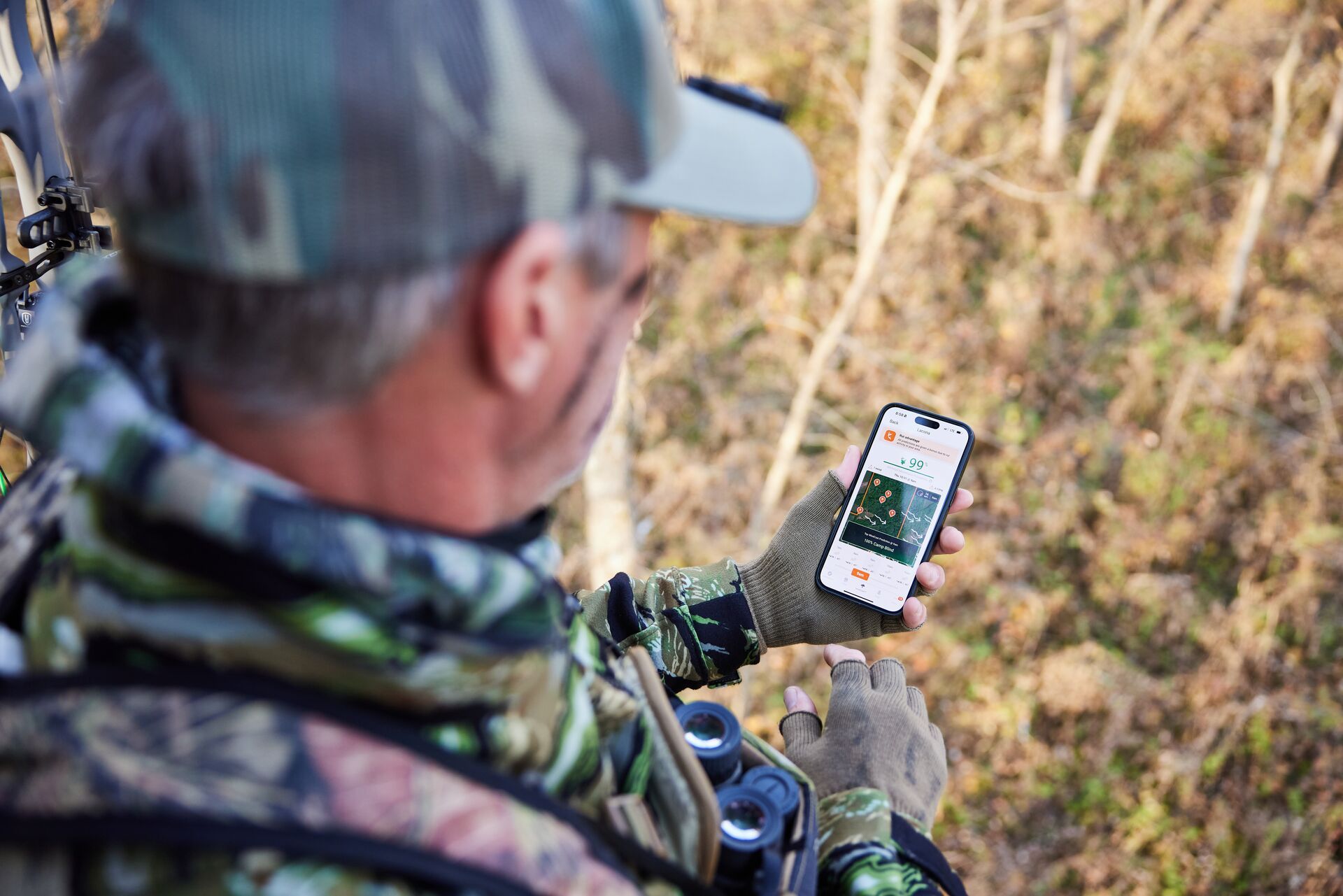 A hunter looks at HuntWise on a phone screen, know private land hunting laws and boundaries concept. 