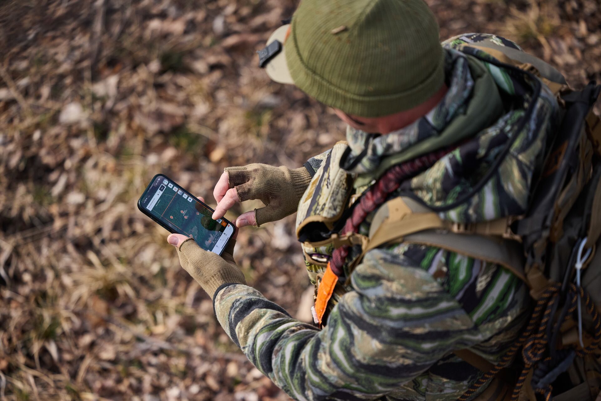 John Dudley looks at a phone showing HuntWise while in the field.