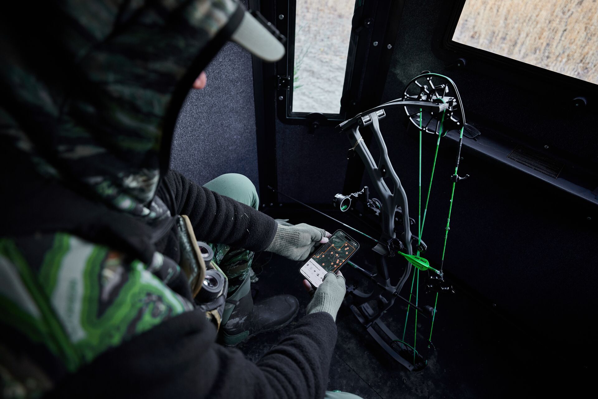 Hunter using HuntWise app while waiting in hunting blind. 