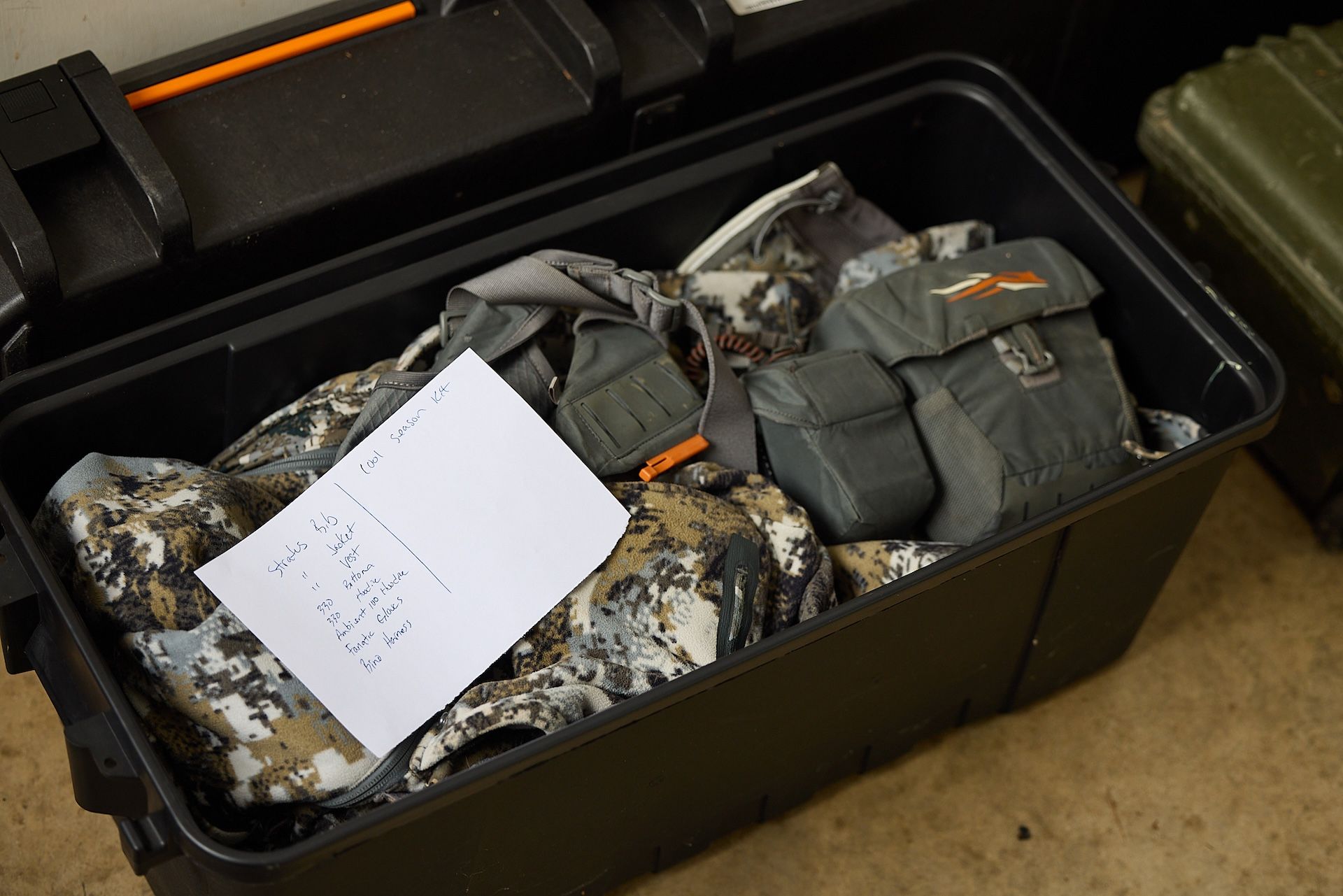 Hunting items in bin with list, how to store hunting gear concept. 