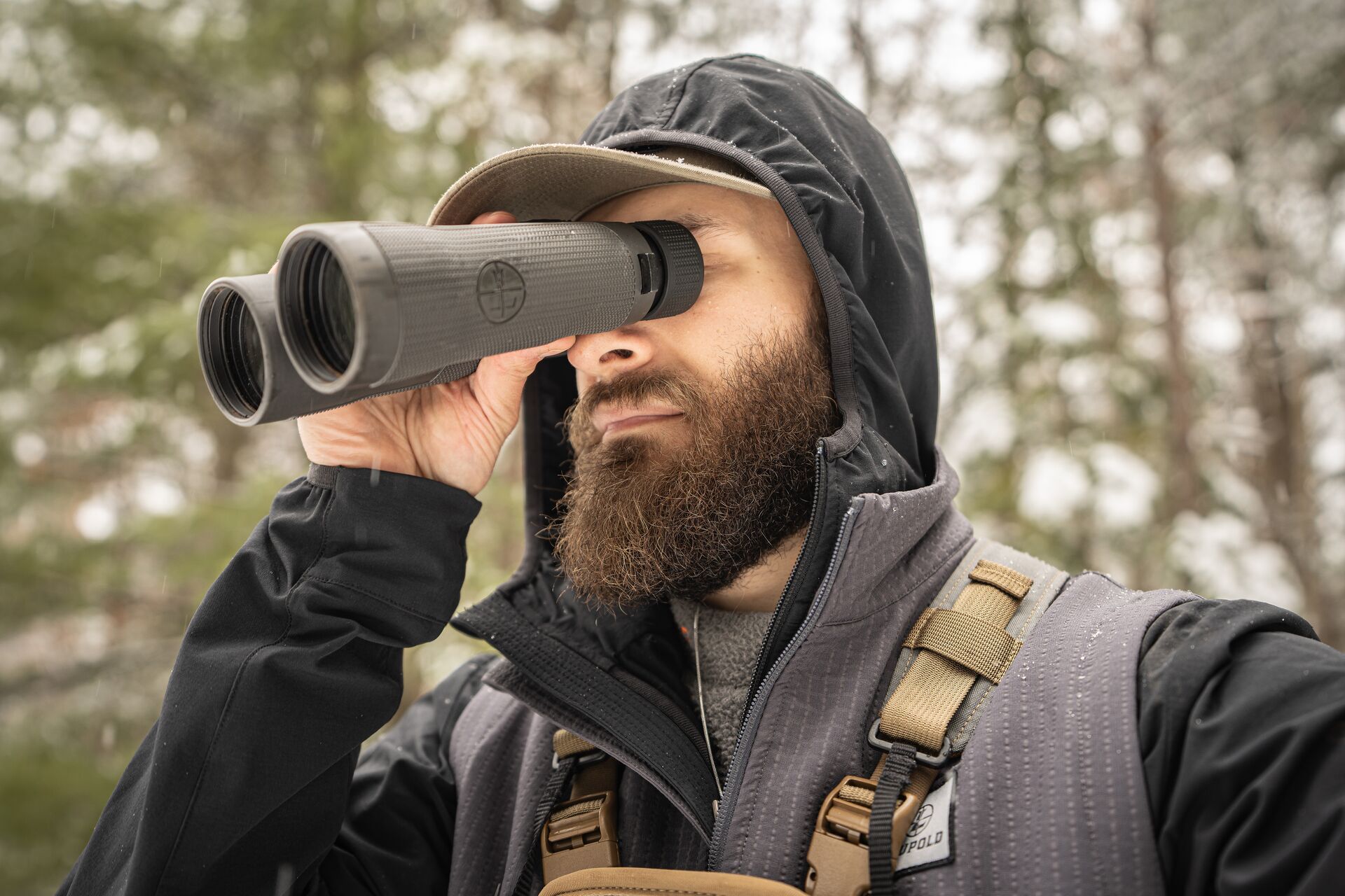 Hunter using binoculars in the woods, what does elk scat look like concept. 