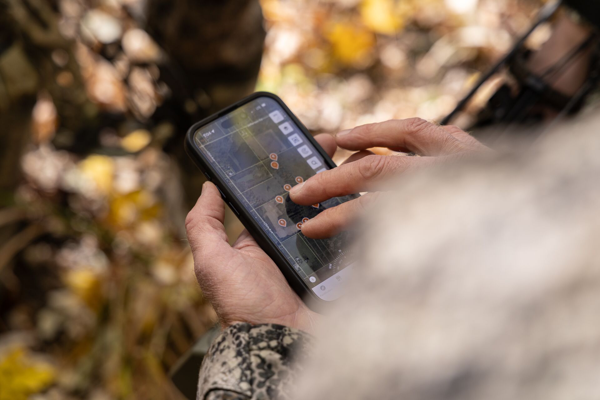 A phone shows the HuntWise hunting app to plan a late-season hunt. 