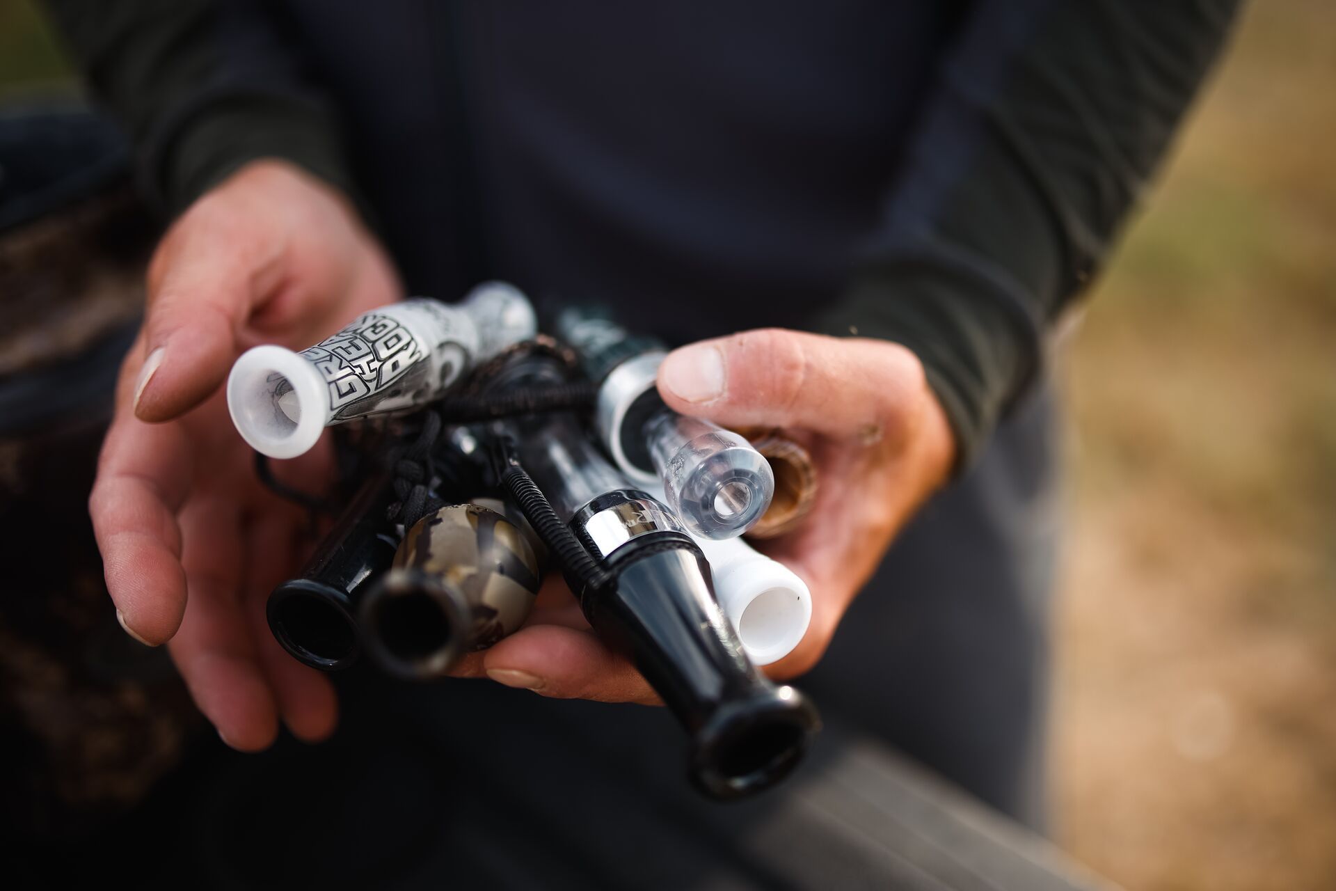 Hands holding various duck calls, best duck calls concept. 