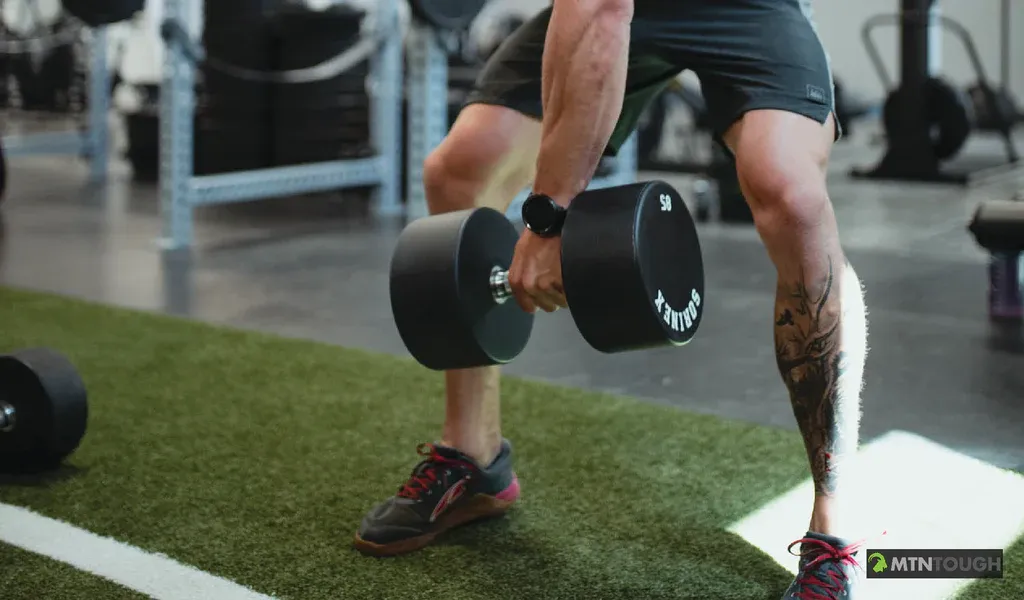 Close-up of a man holding a dumbbell, hunting exercises concept. 