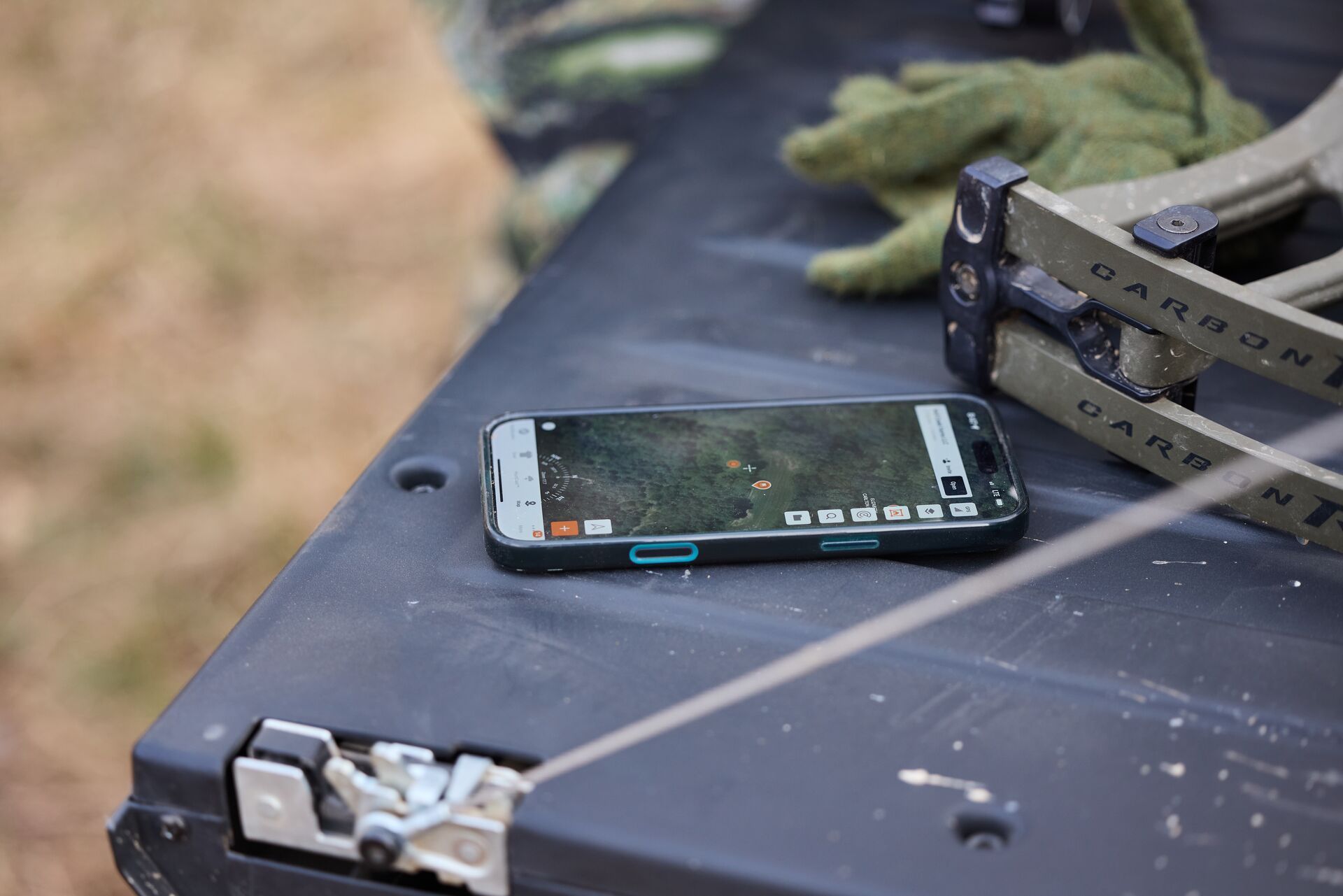 Cellphone showing the HuntWise hunting app sits on a truck tailgate.