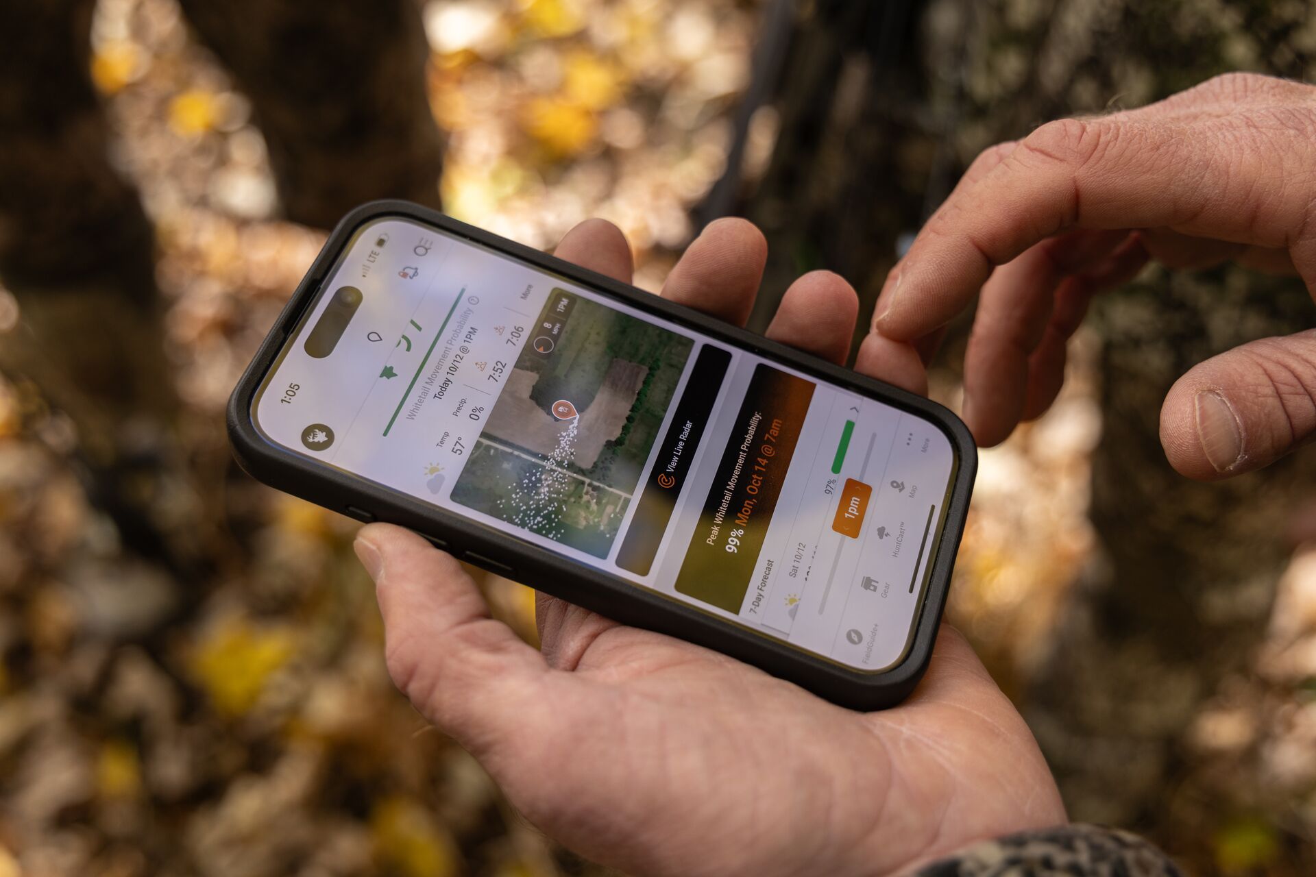 Close-up of hands holding a phone while using the HuntWise hunting app. 