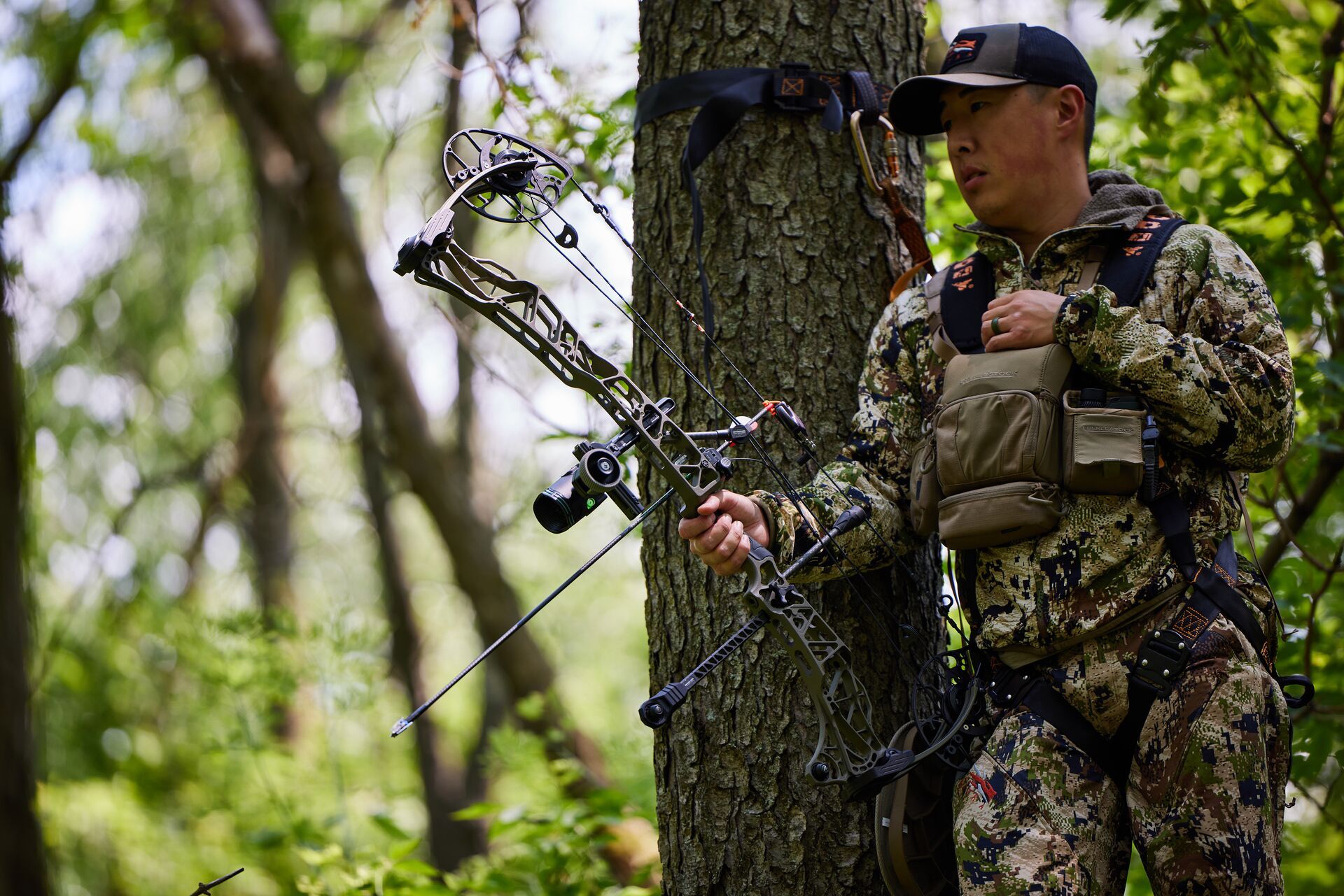 A bowhunter in a tree with light weight hunting gear.