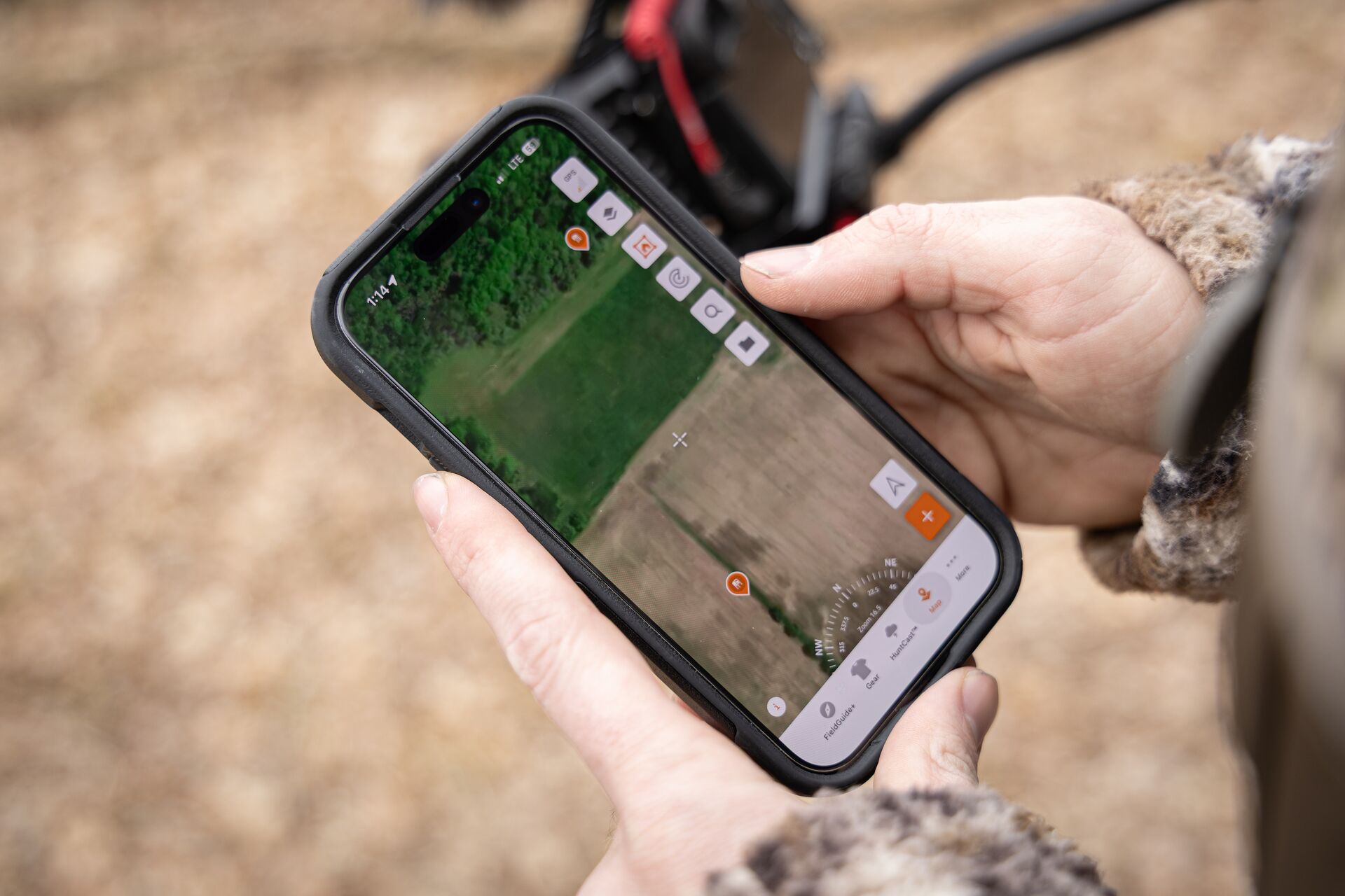 Close-up of a phone screen showing HuntWise maps, how to find last minute land concept. 