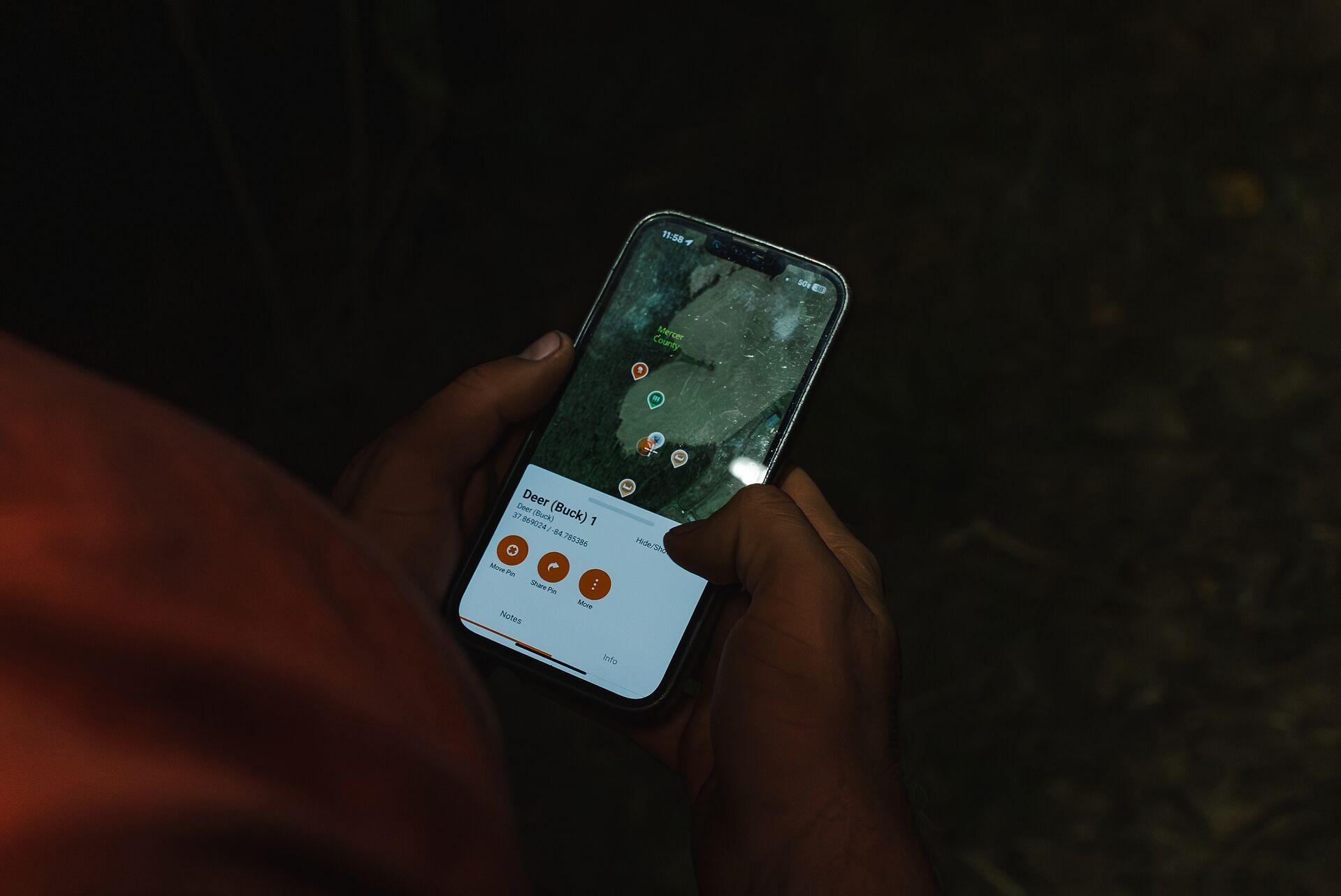 Hands holding a phone showing HuntWise maps on screen, where can I hunt near me concept. 
