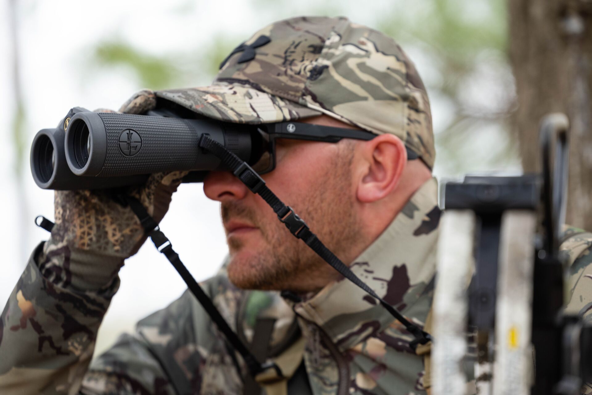 Hunter using binoculars, turkey hunting in the wind concept. 