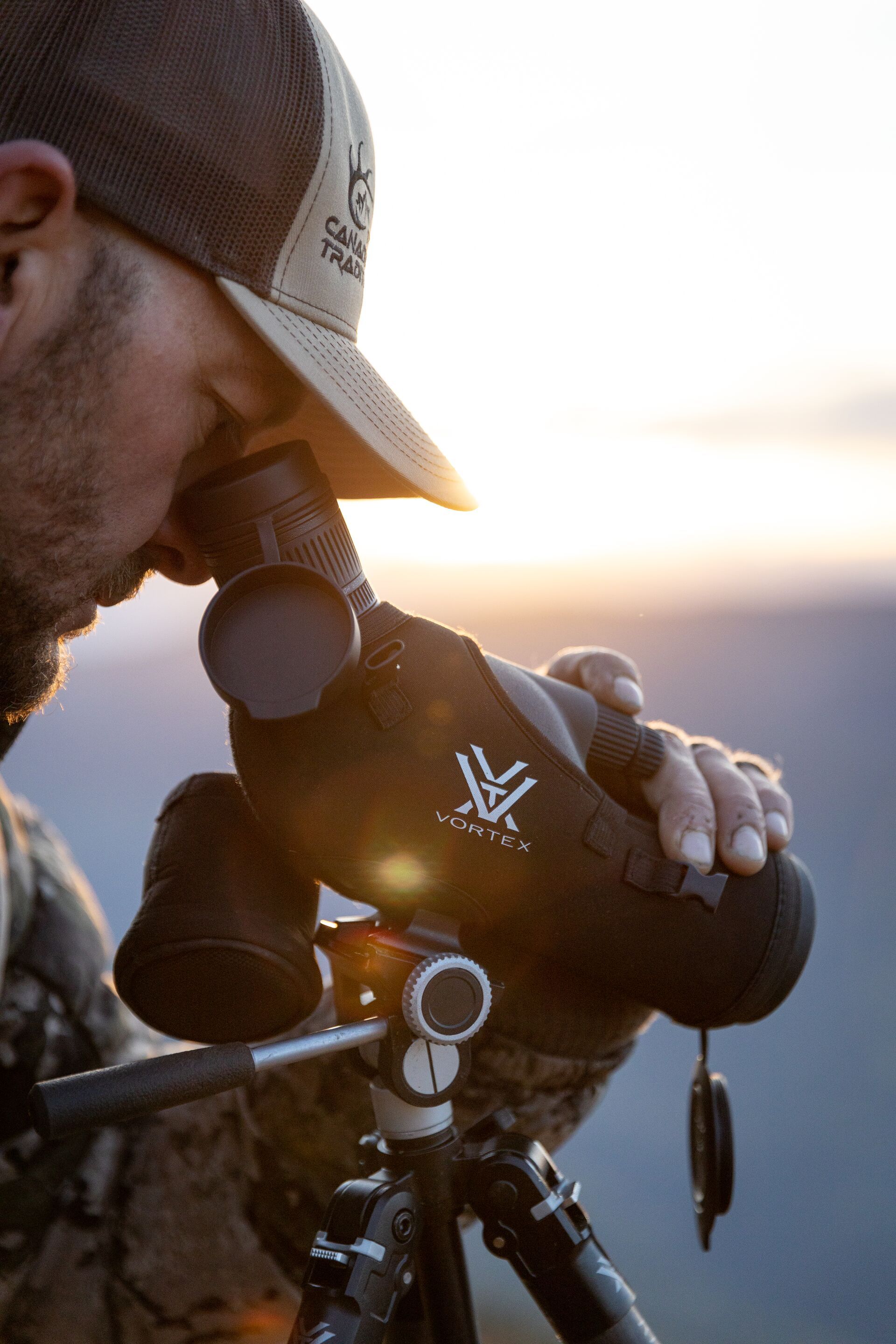 Close-up of hunter using spotting scope, how to find mule deer concept. 