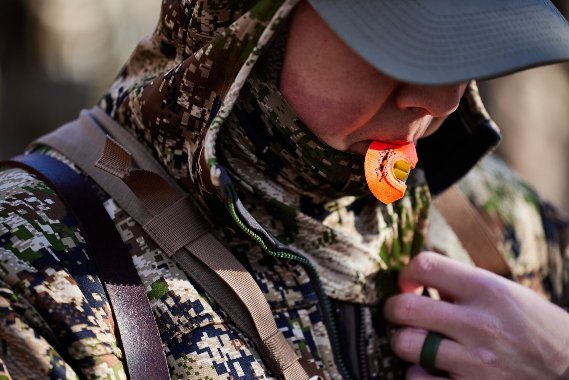 Close-up of hunter with diaphragm turkey call in his mouth.
