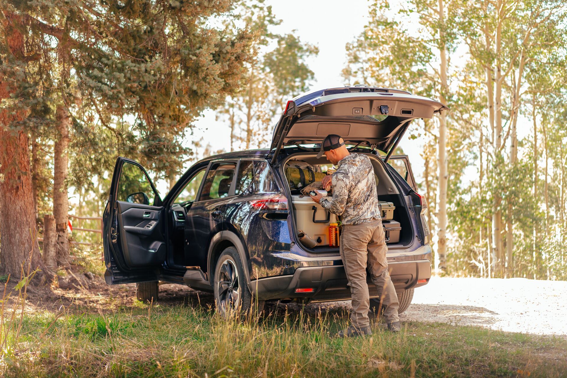 A hunter accesses hunting gear in the back of a car. 