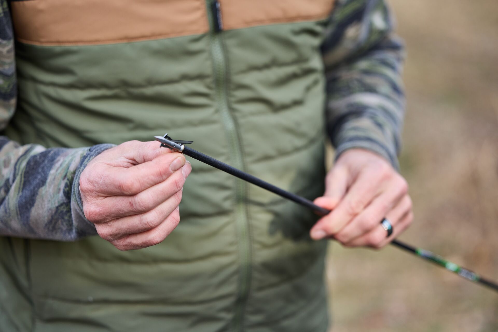 Close-up of hunter holding the tips of an arrow attached to the shaft. 