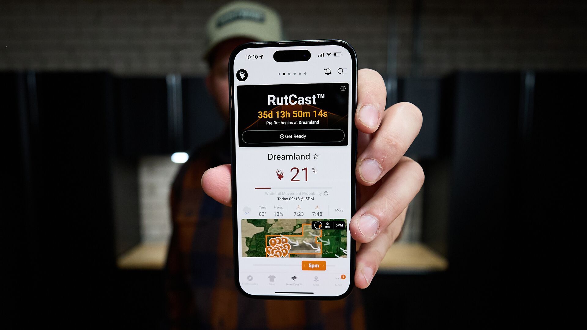 Hunter holds phone showing HuntWise RutCast on screen, best deer grunt call timing and tips concept. 