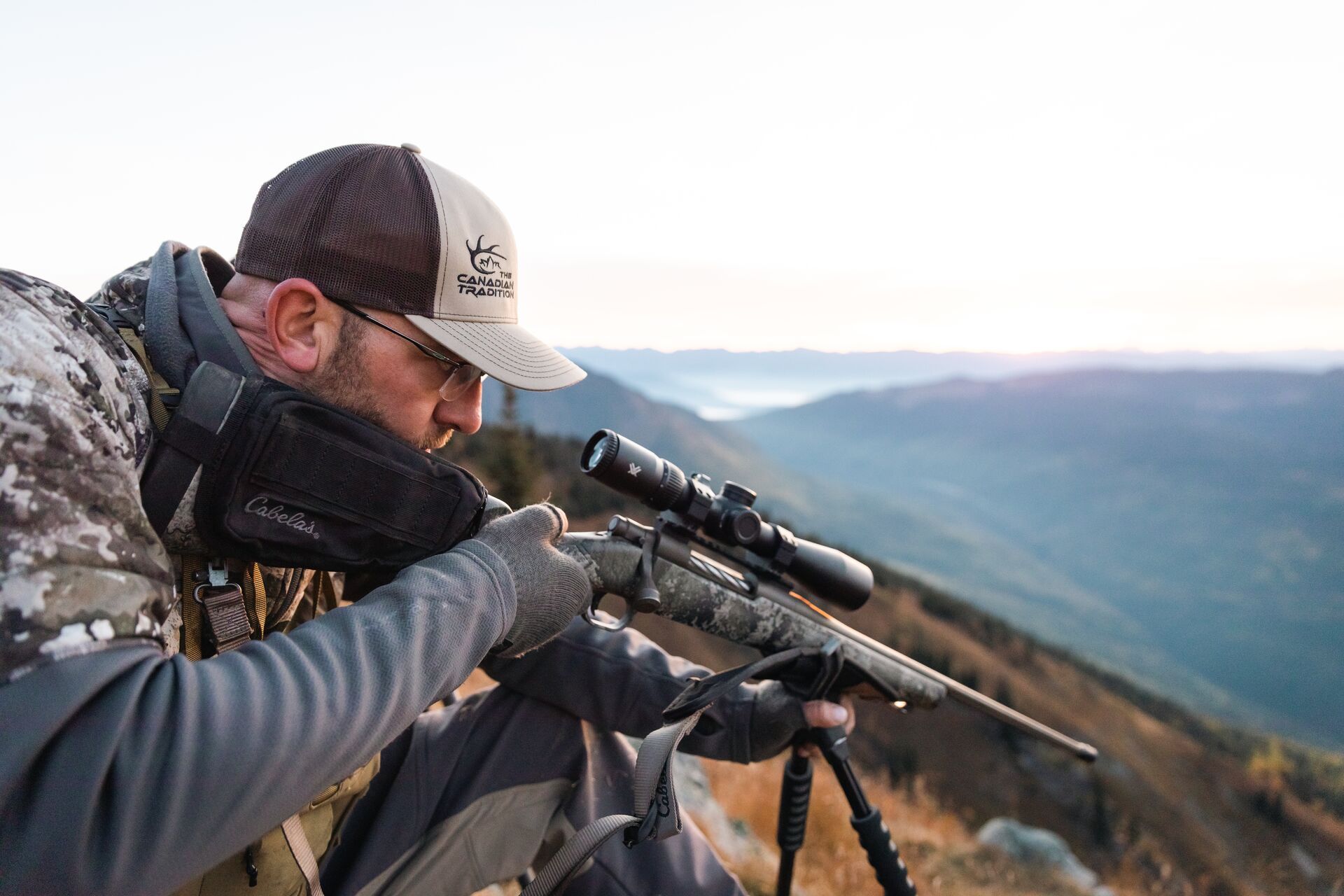 Hunter in the field aims bolt action hunting rifle. 