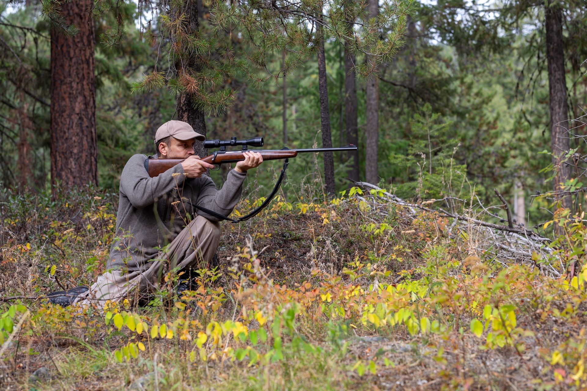 Hunter in kneeling hunting shooting position. 
