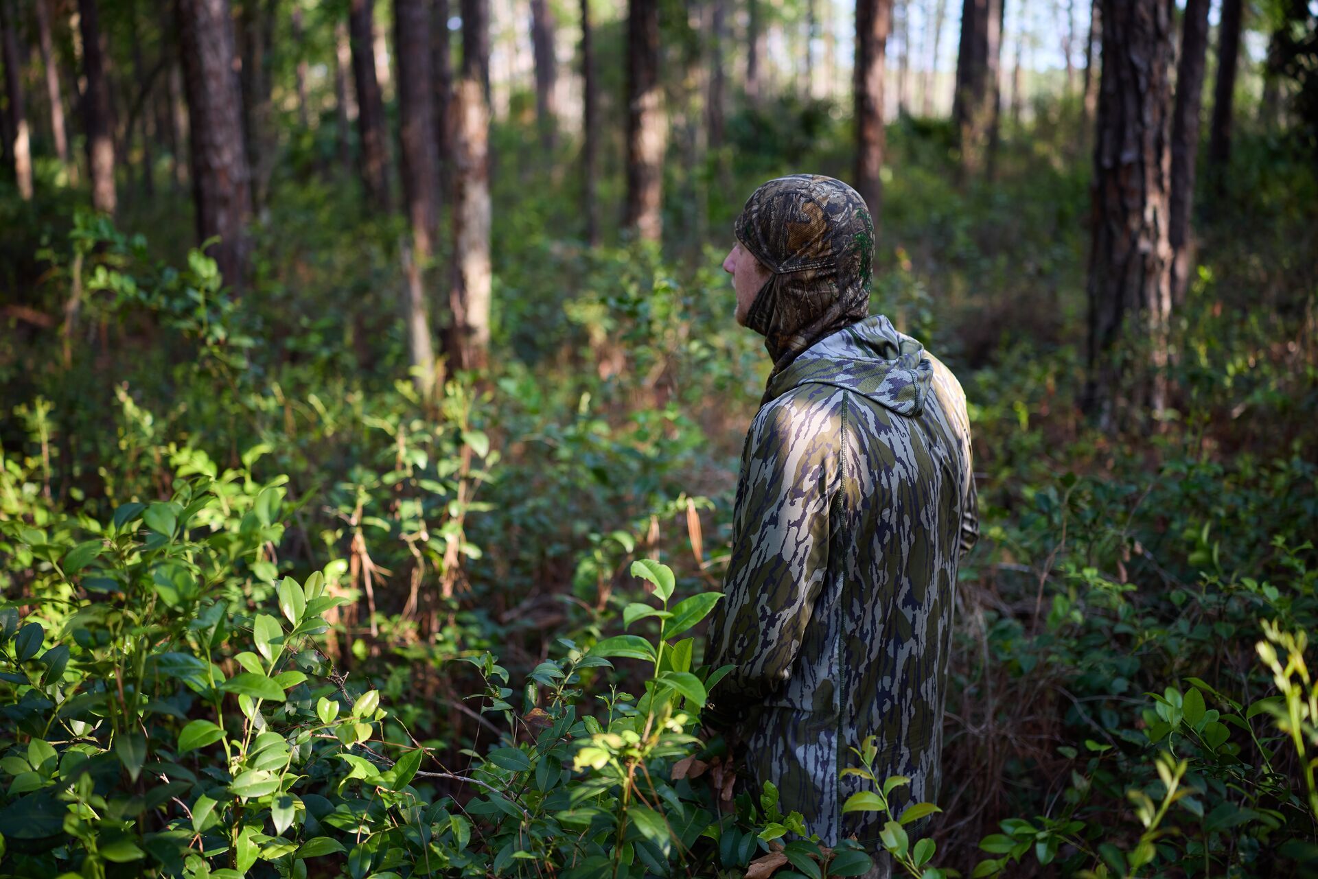 Hunter in the brush in warm-weather camo clothing.