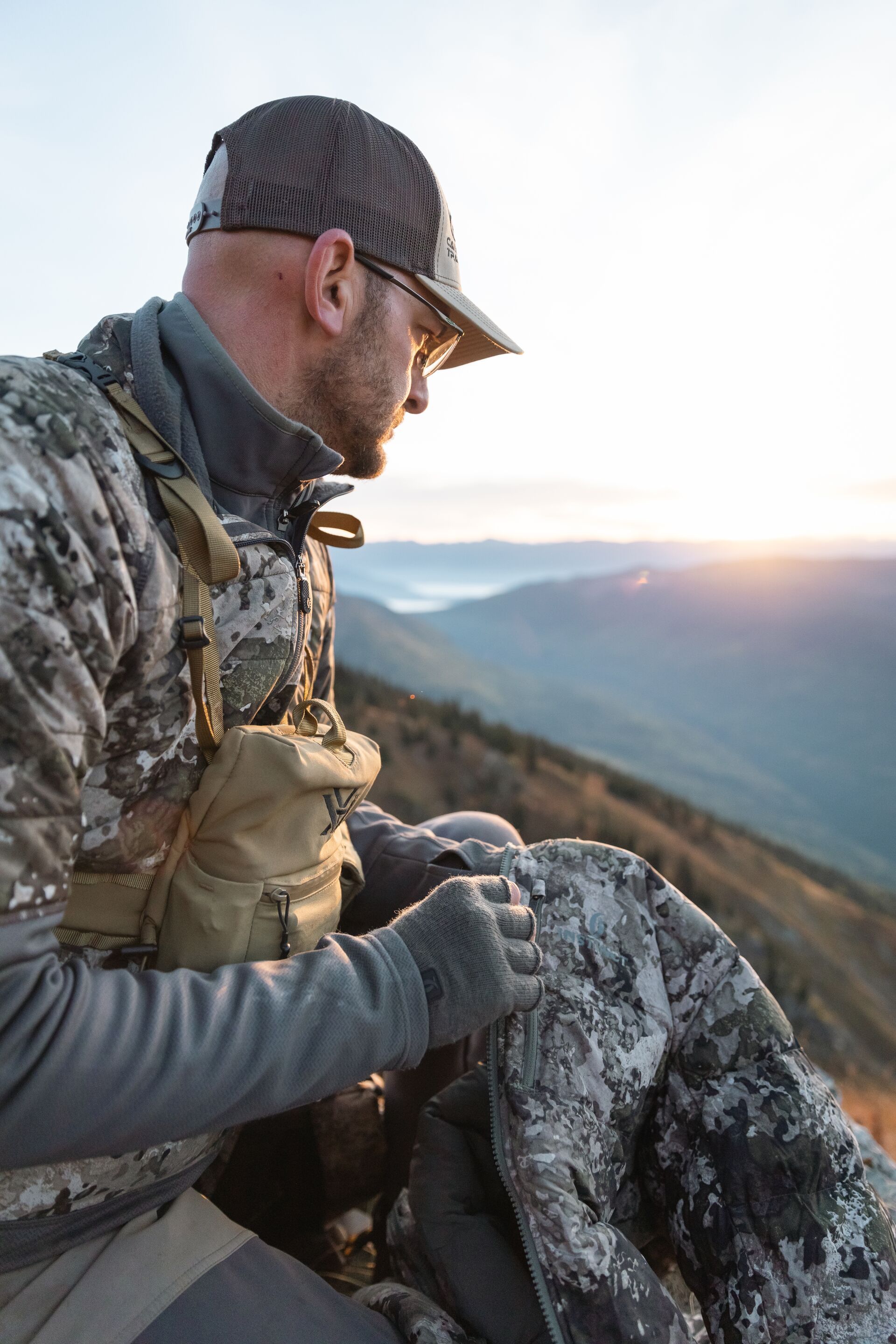 Hunter on mountain looks into valley, how to find mule deer concept. 