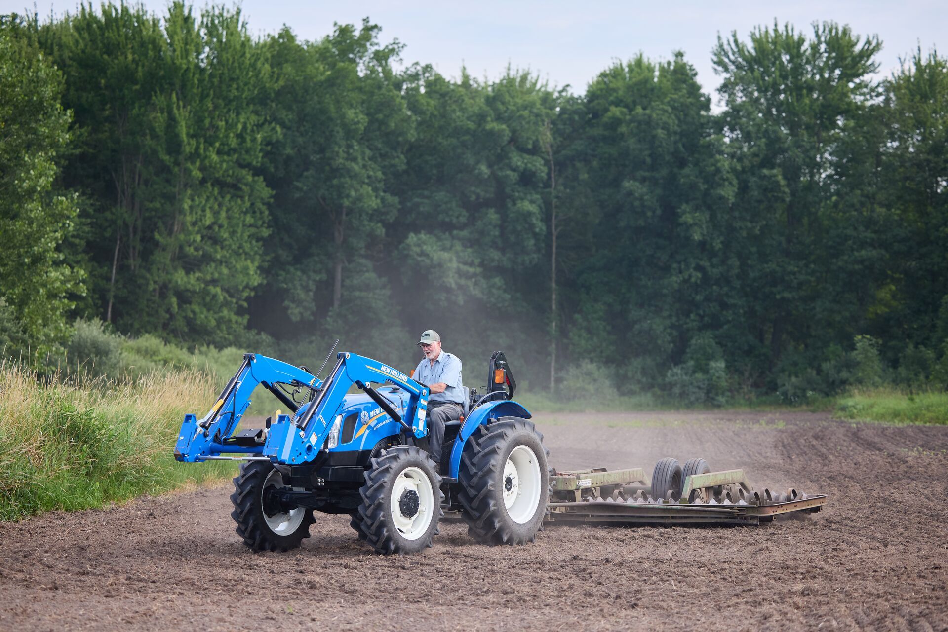 Hunter on tractor prepares ground to plant food plot, perennial clover for deer concept. 