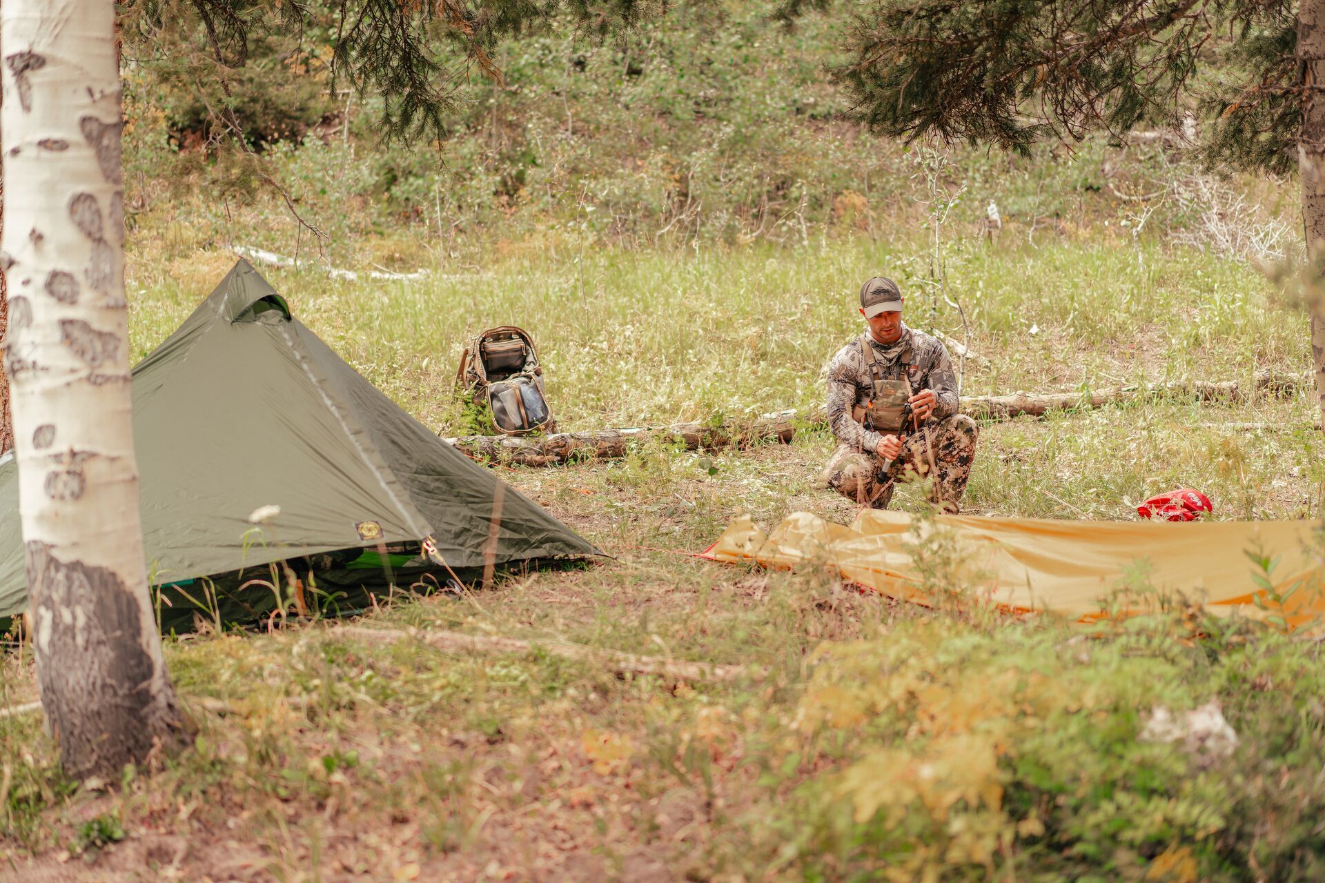 Hunter sets up camp in the woods. 