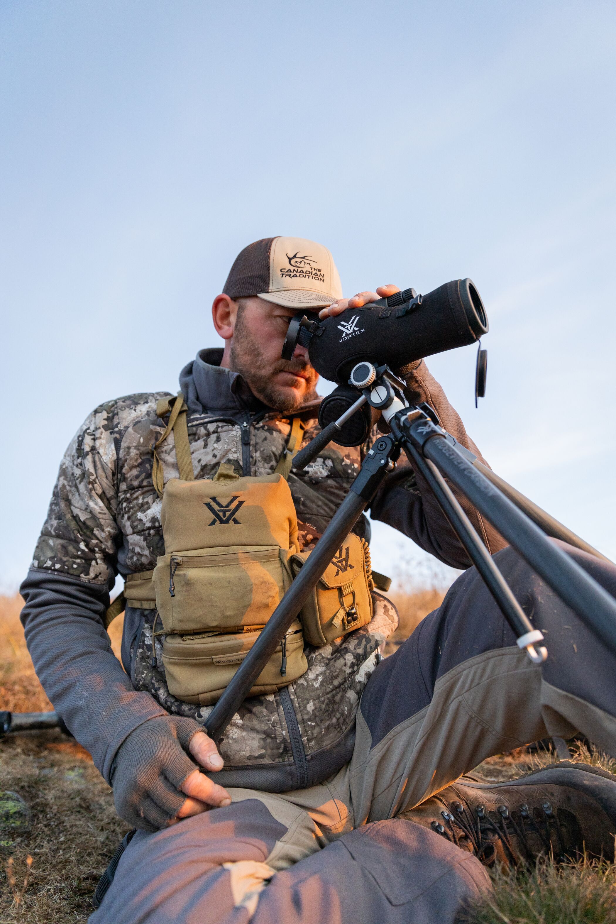 A hunter sits while glassing, glassing for mule deer concept. 