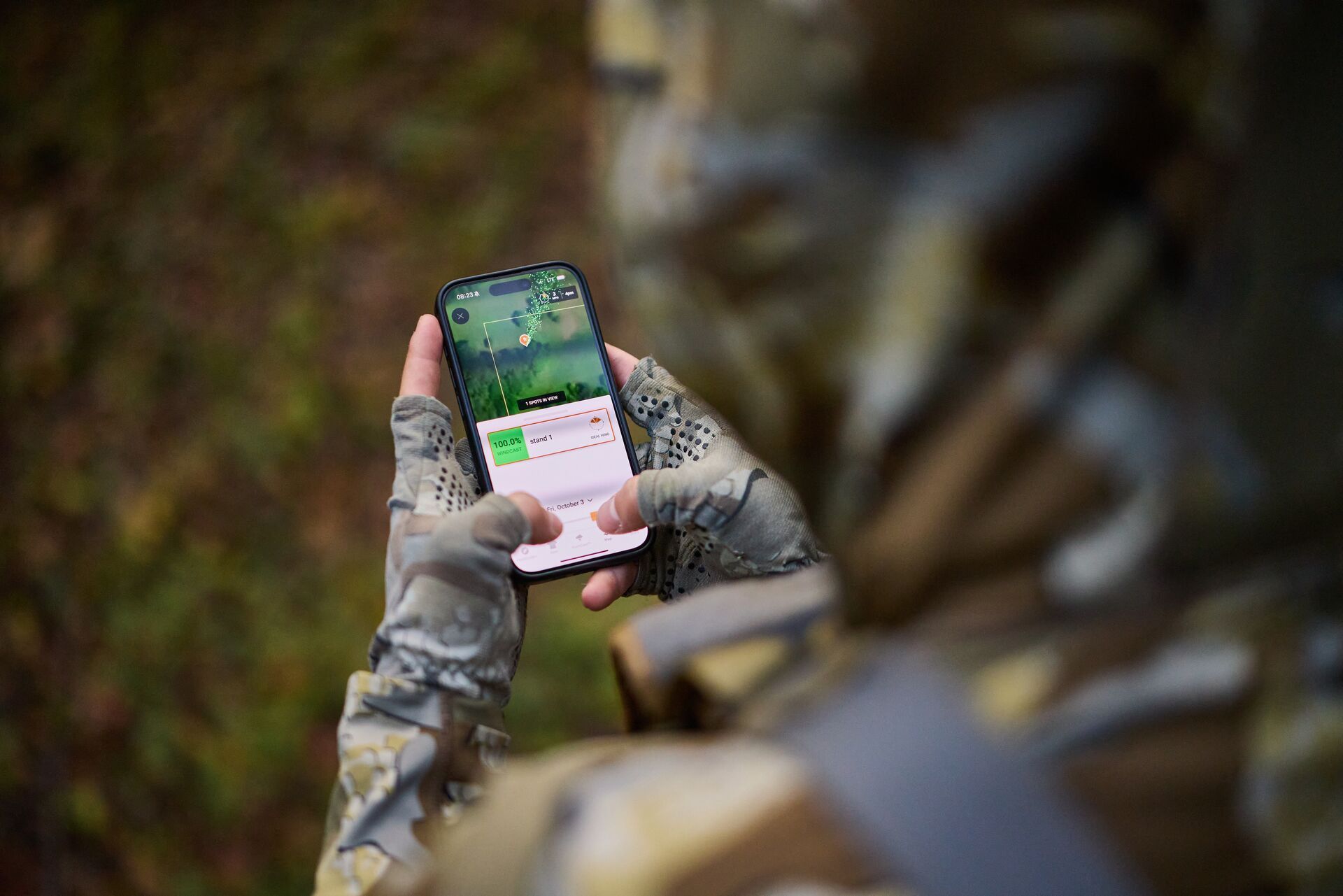 Hunter using HuntWise hunting app features on phone.