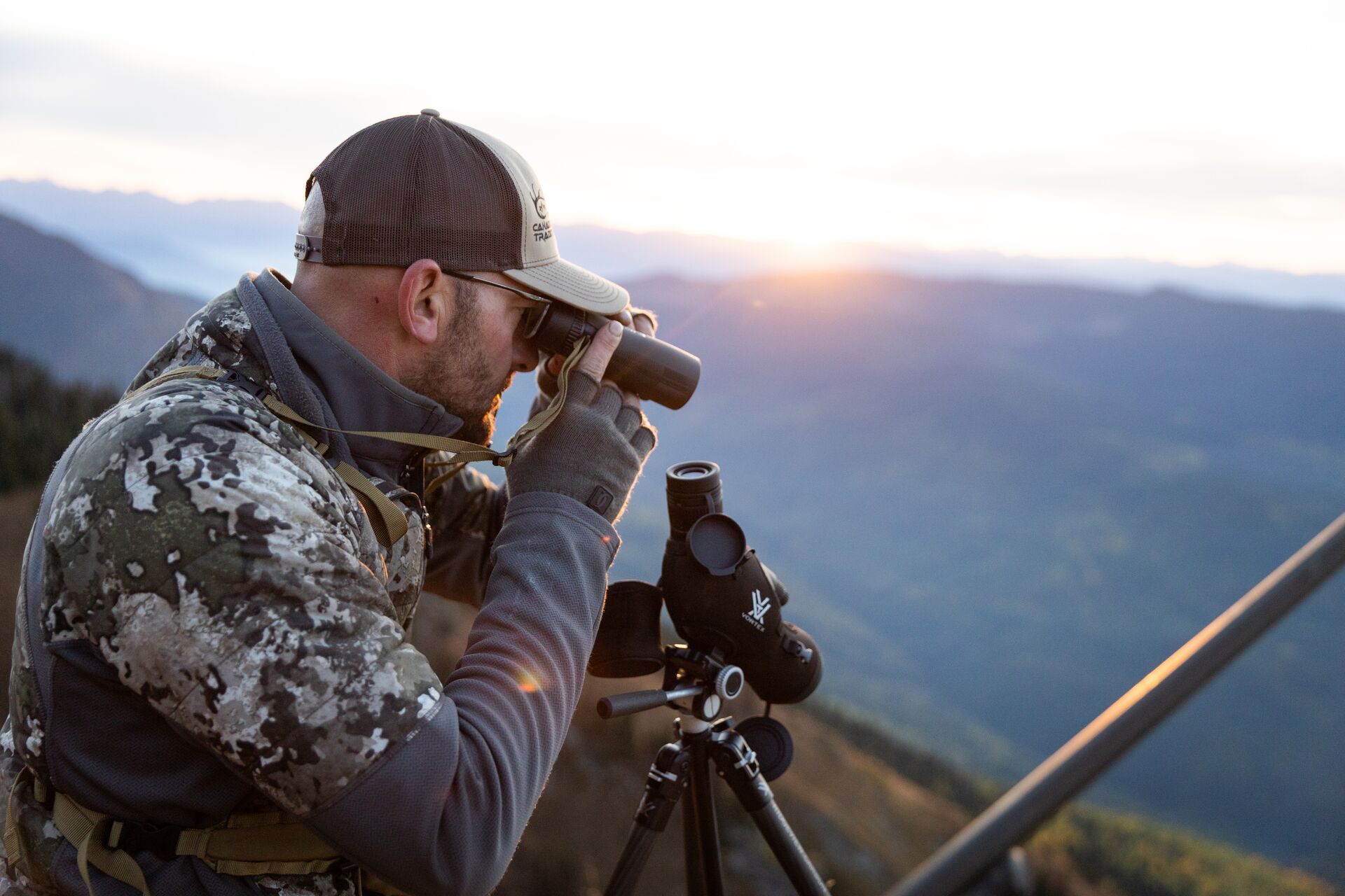 Hunter using binoculars and scope, mule deer scouting tips concept. 