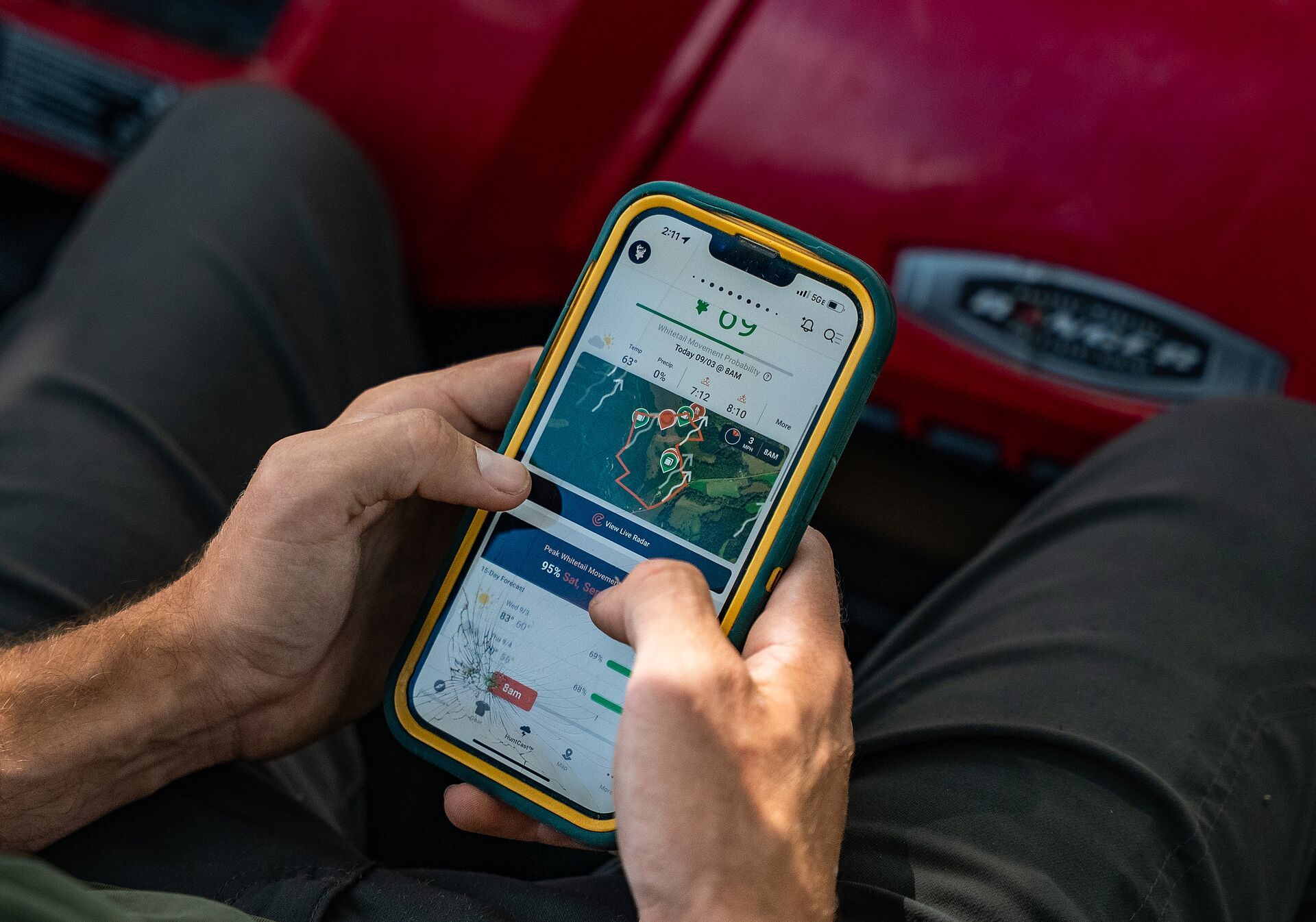 Hunter using a phone with the HuntWise app on screen. 