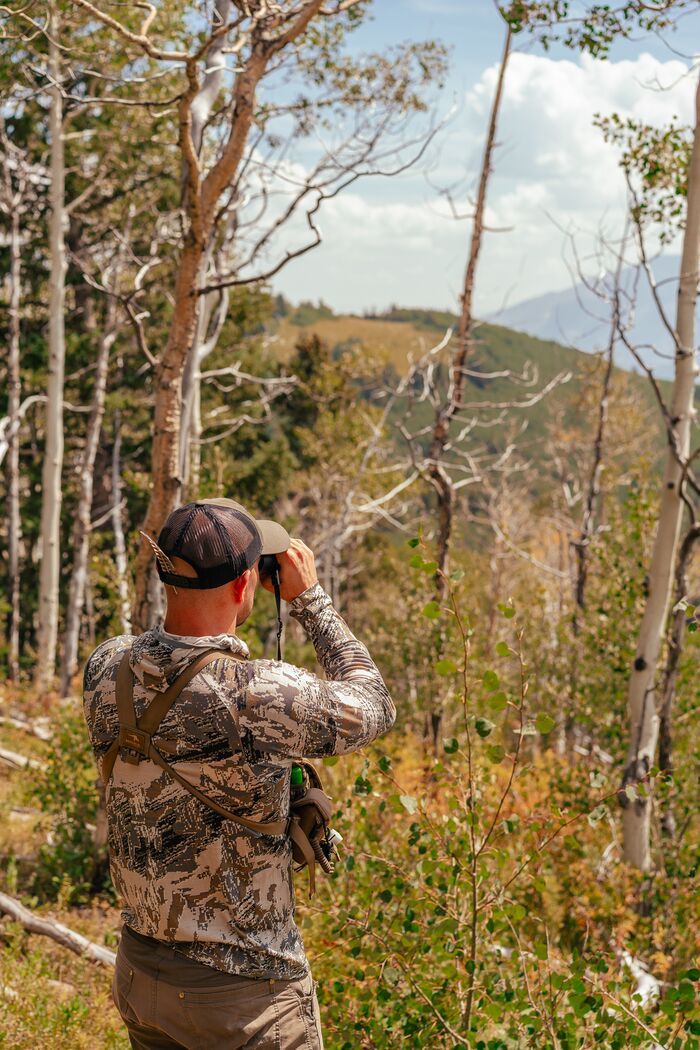 Hunter using binoculars to scout. 