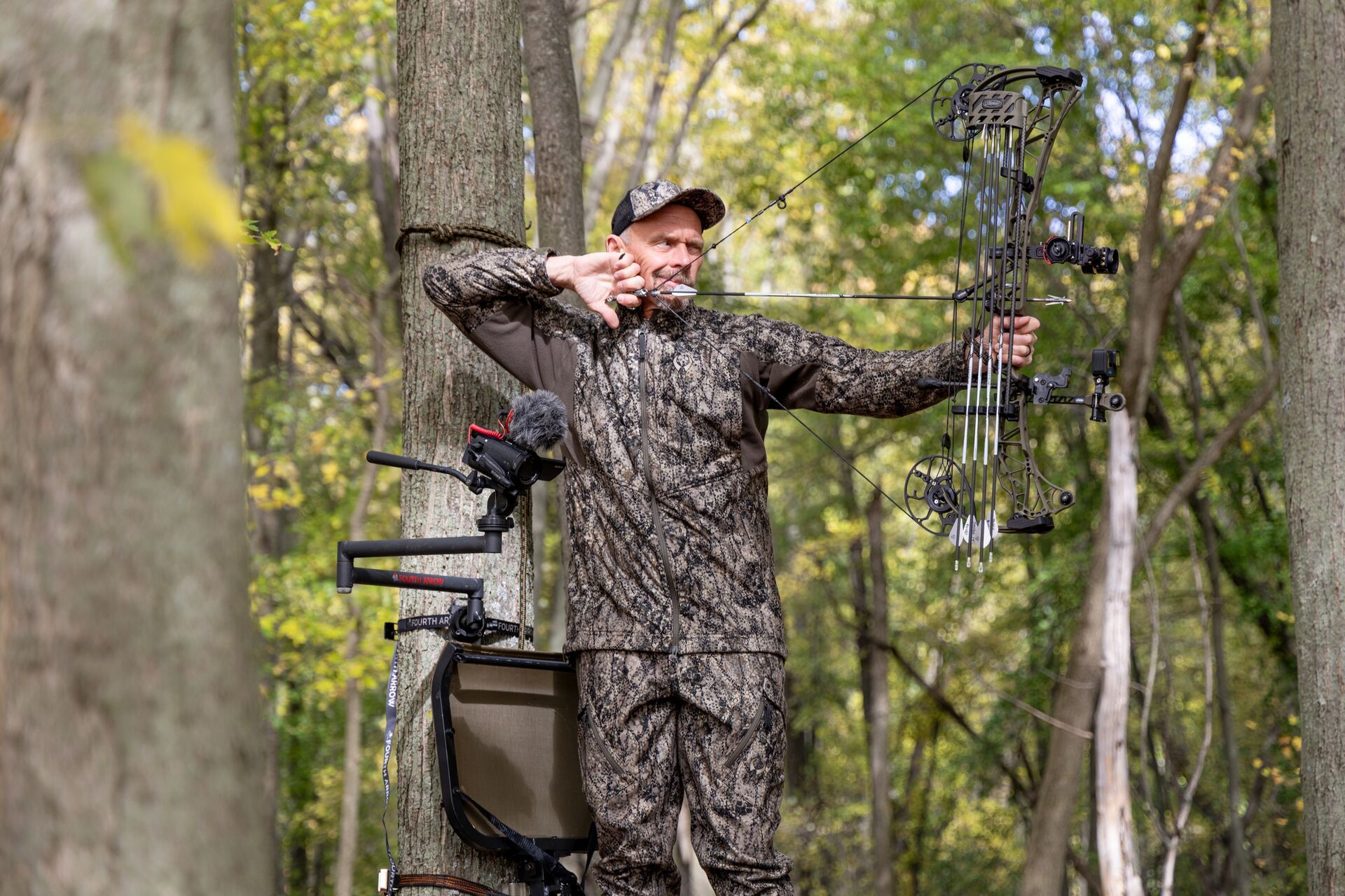 A hunter in a tree stand draws a bow, what is a broadhead concept. 