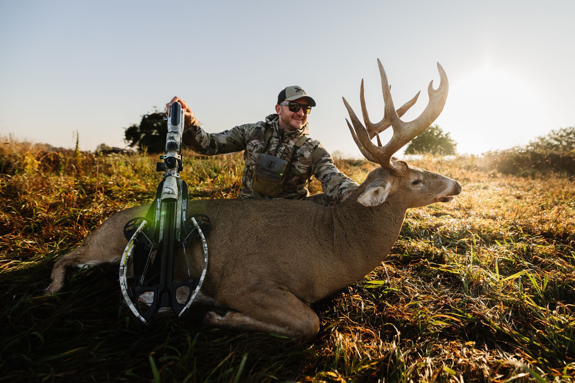 A hunter shows off a bow and buck deer after a kill, Oregon deer season concept.