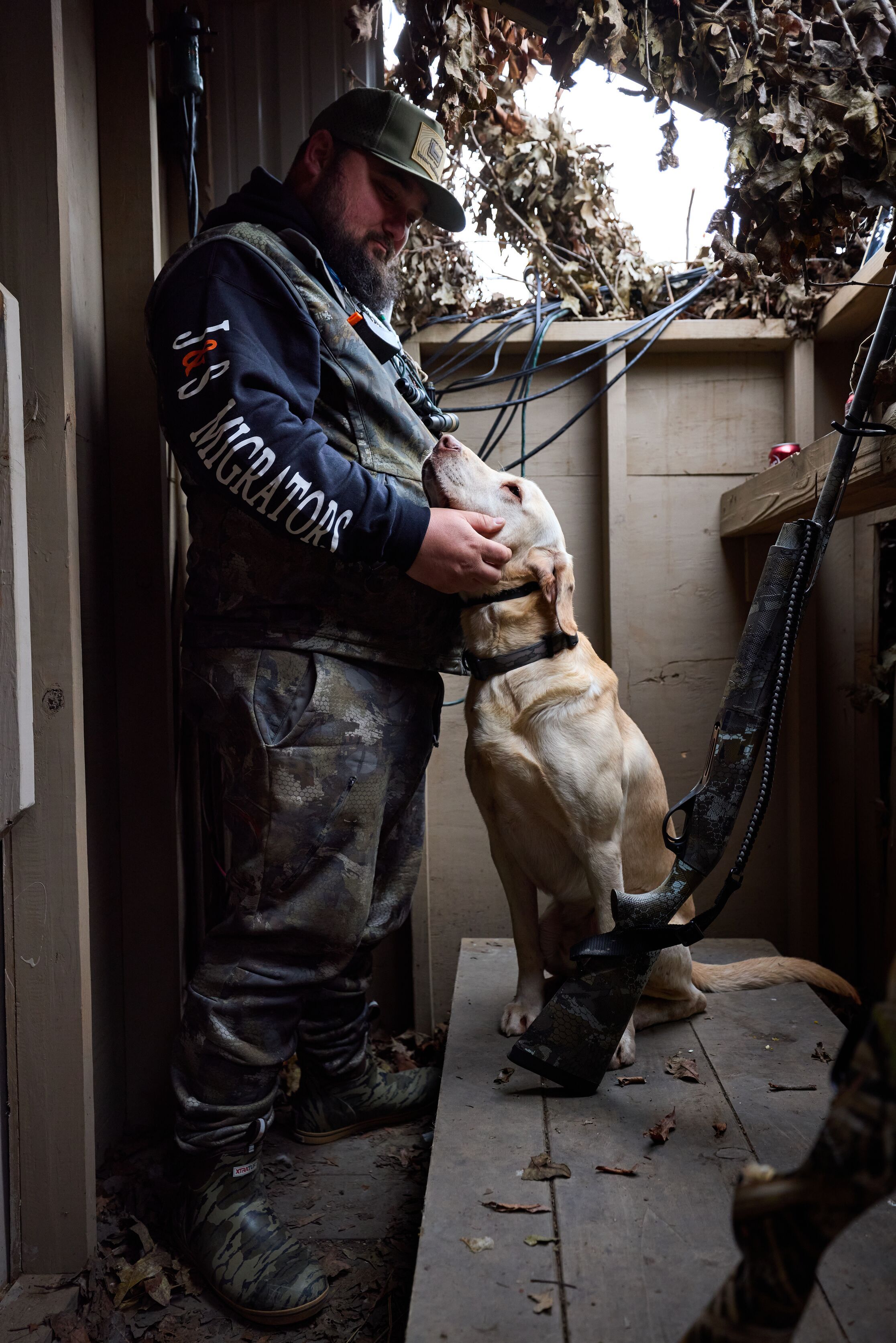 Hunter with dog and shotgun in duck blind, shotgun for hunting concept. 