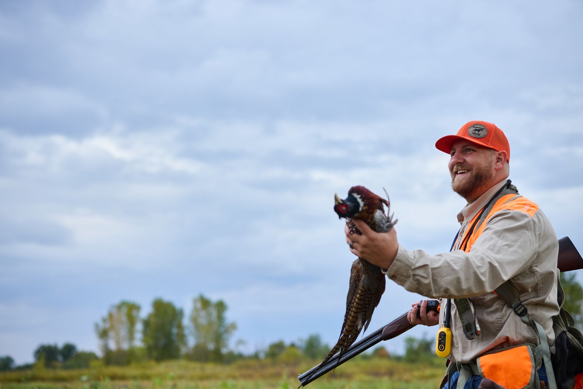 Hunter with pheasant during hunt, best time for upland game hunting concept.