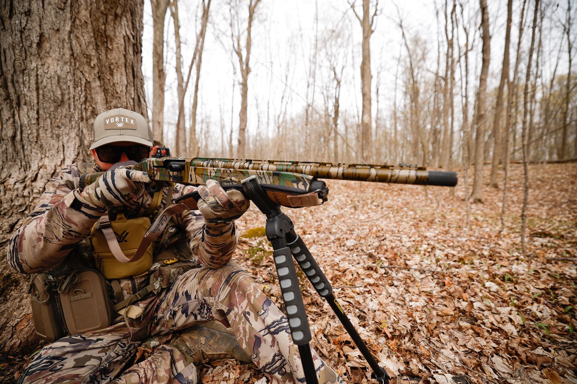 Hunter with firearm in sitting position, hunting shooting positions concept. 