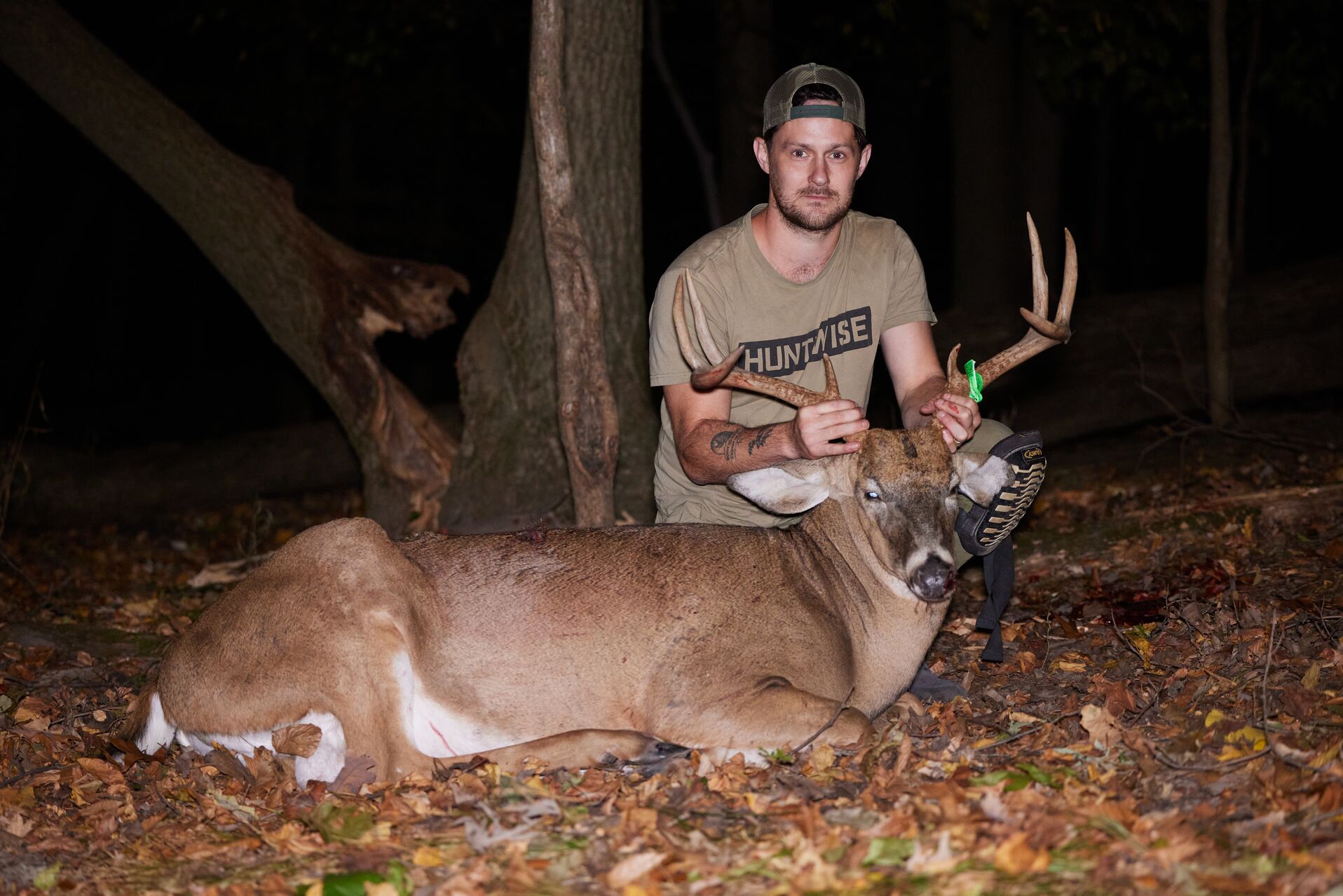 A hunter poses with a deer after a hunt.