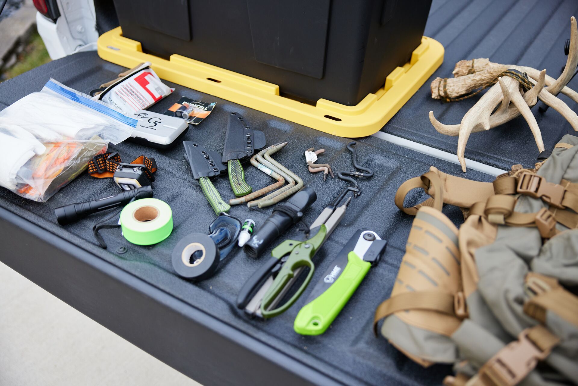 Knives and other hunting gear on a truck bed, best hunting knives concept. 