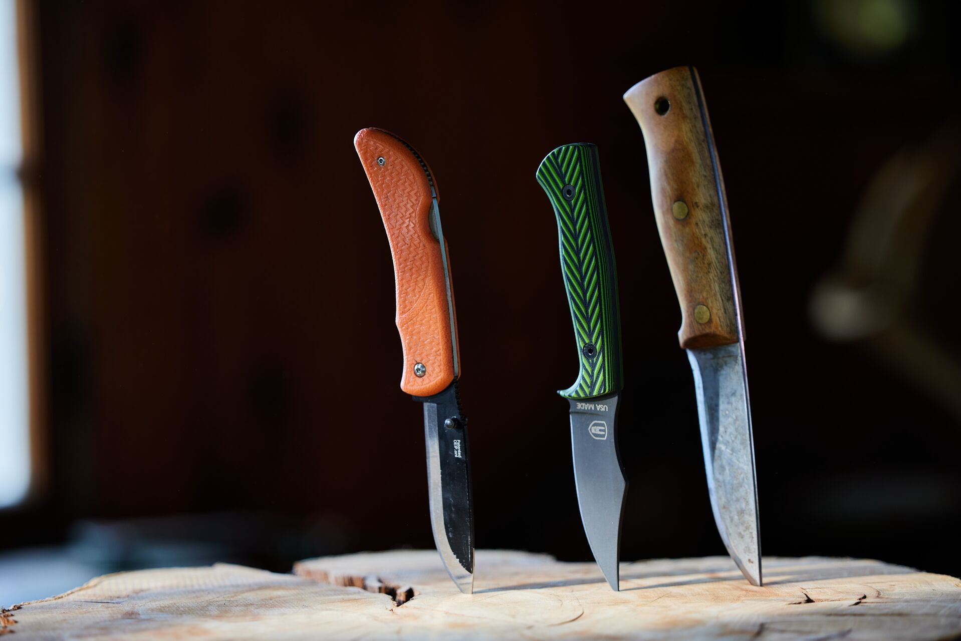 Three hunting knives stuck into a tree stump. 