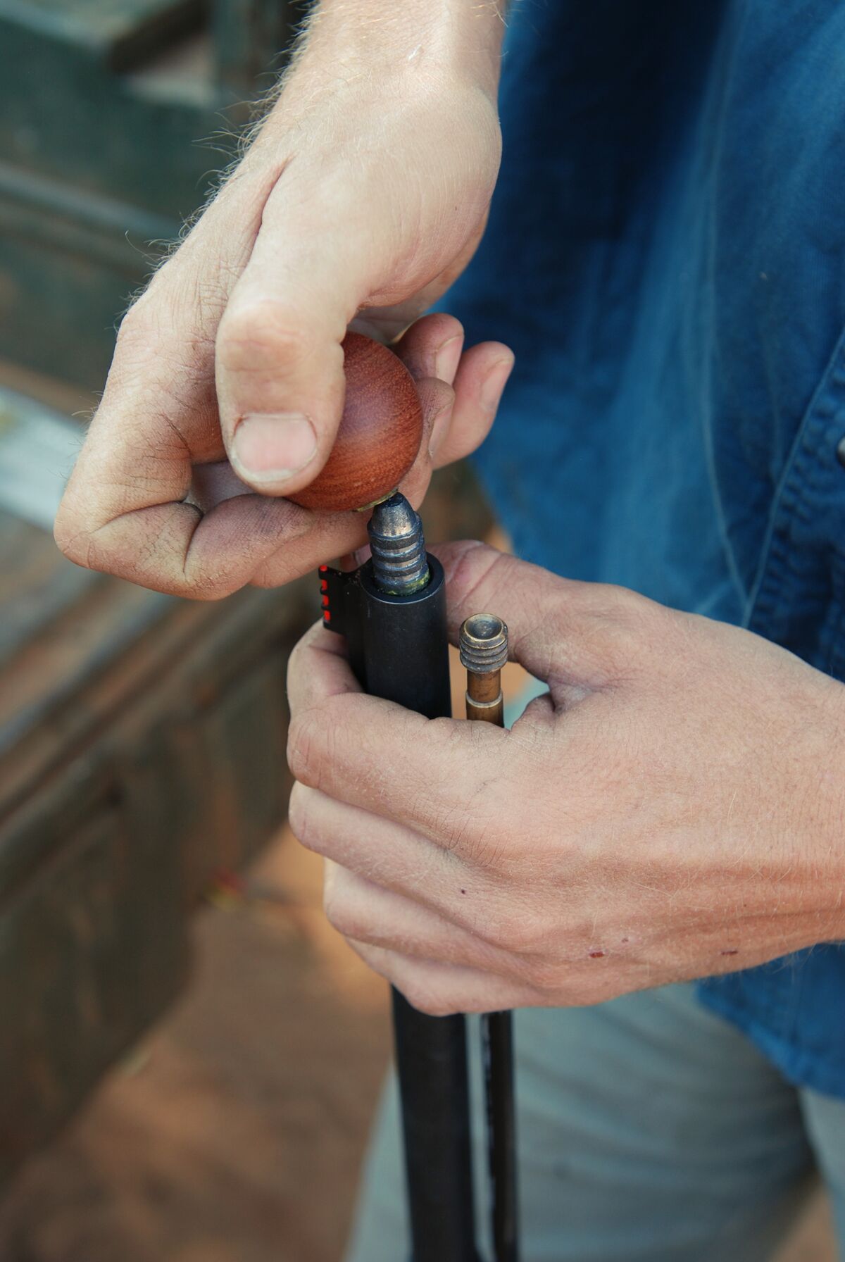 Close-up of hands loading a muzzleloader.