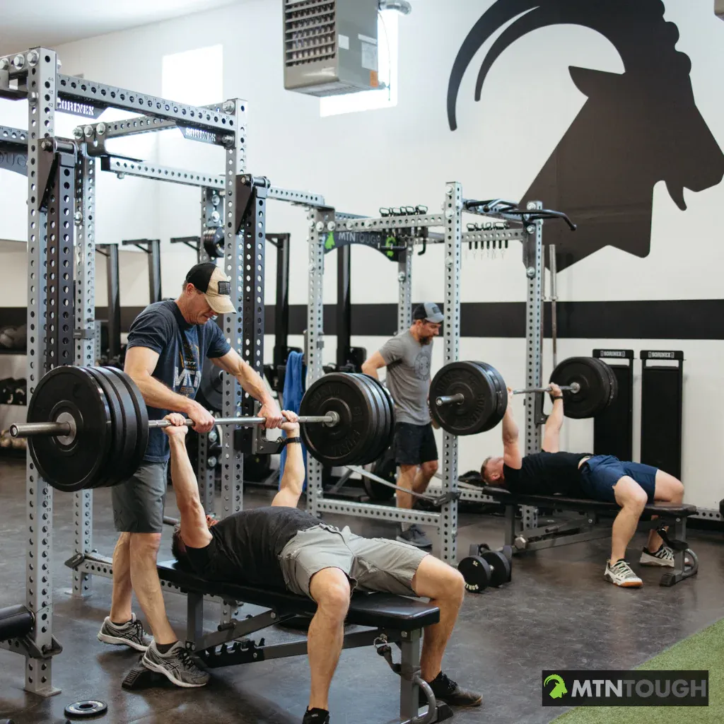 Men lifting heavy weights at the gym.